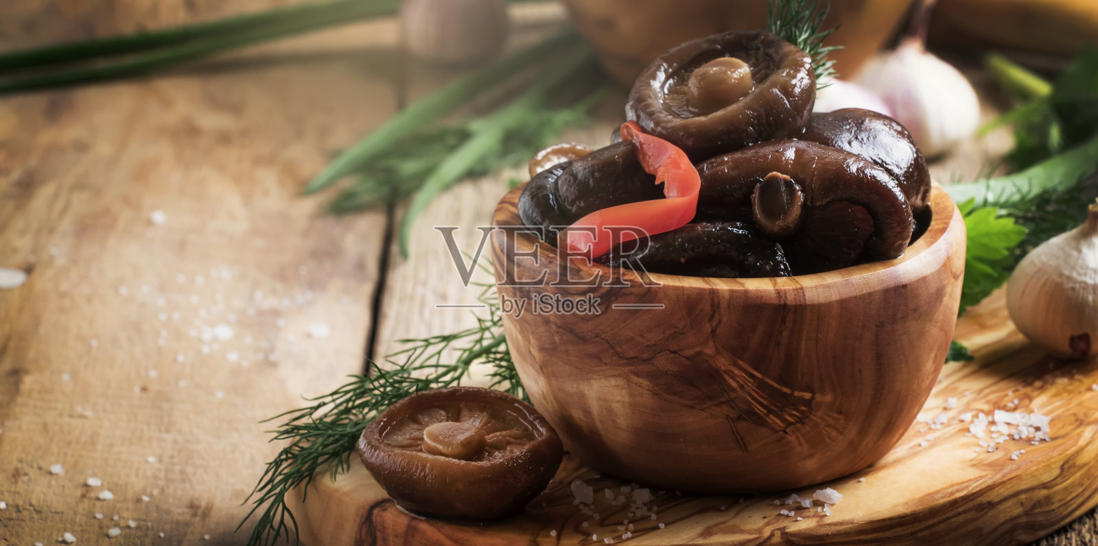 香菇加胡椒和大蒜腌制在木碗里，有选择的重点照片摄影图片