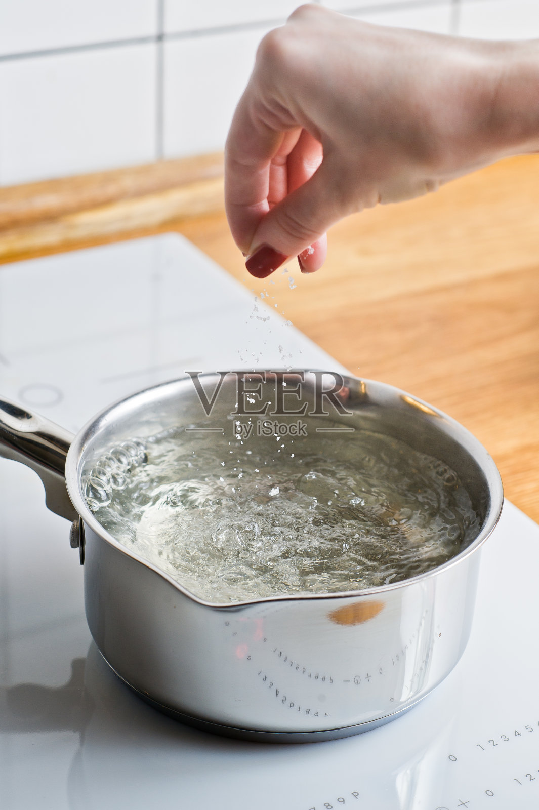 厨师将煮小龙虾的水加盐。厨房的背景。照片摄影图片