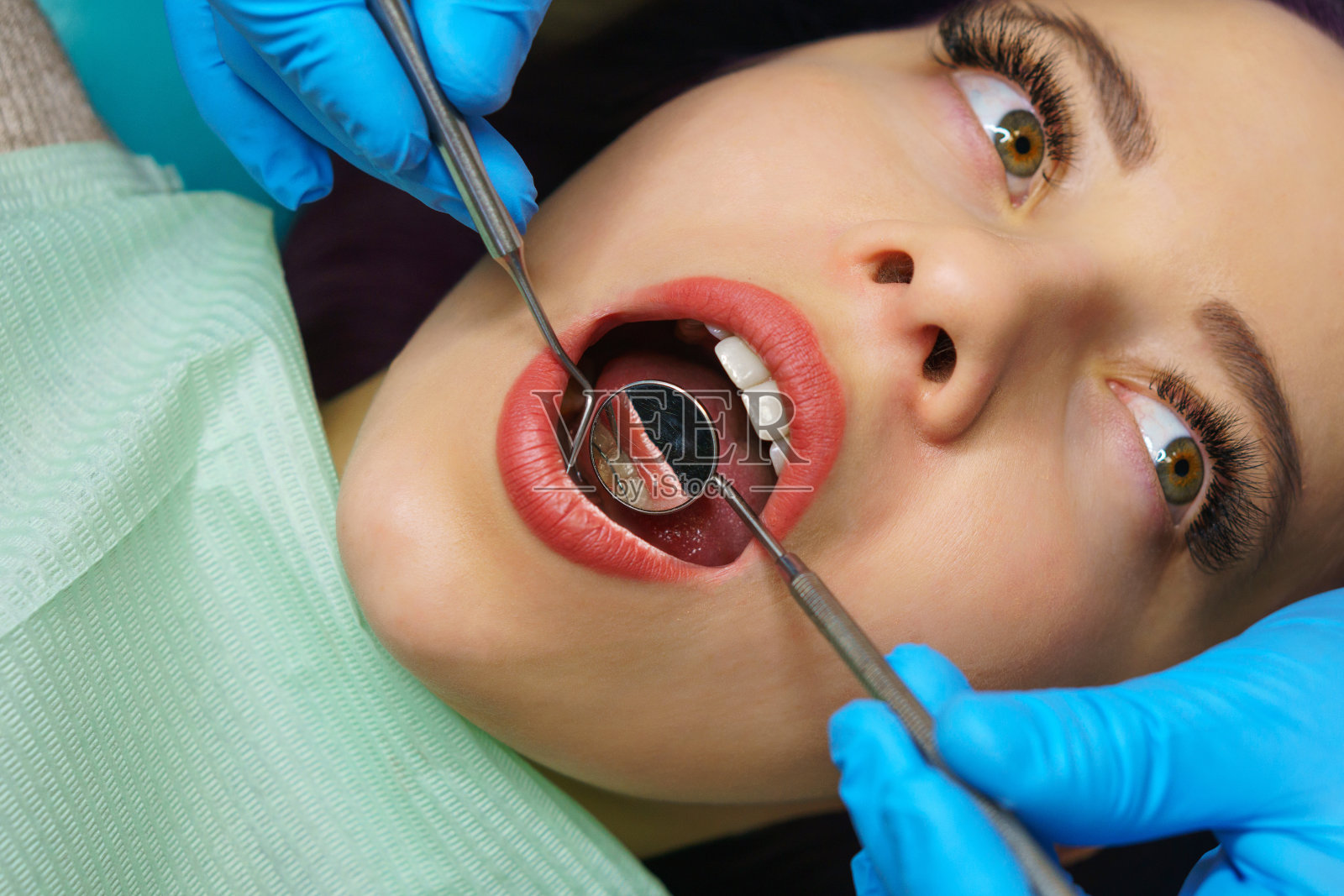 牙医检查女孩的牙齿。照片摄影图片