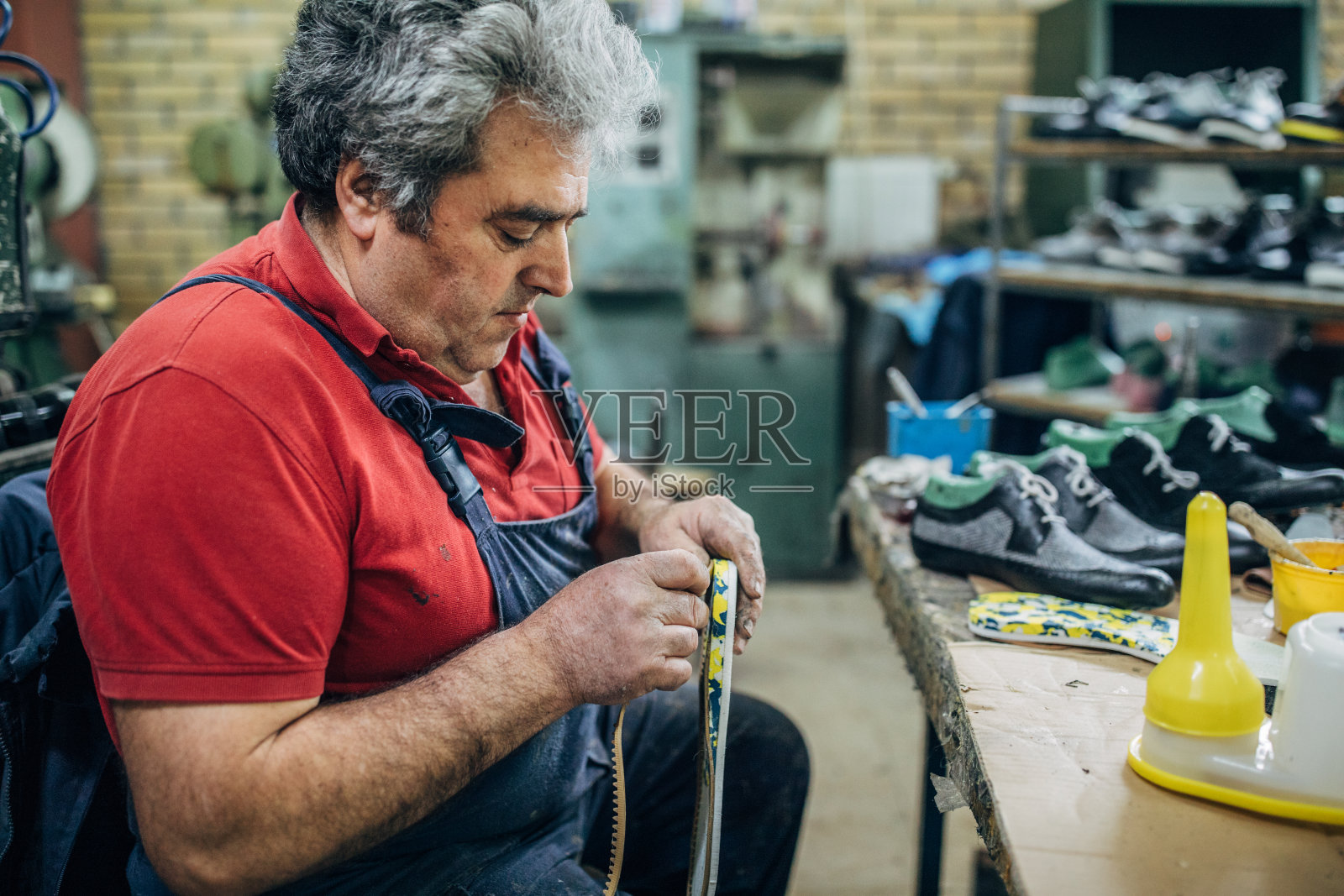 一个成熟的男人在鞋厂独自工作照片摄影图片