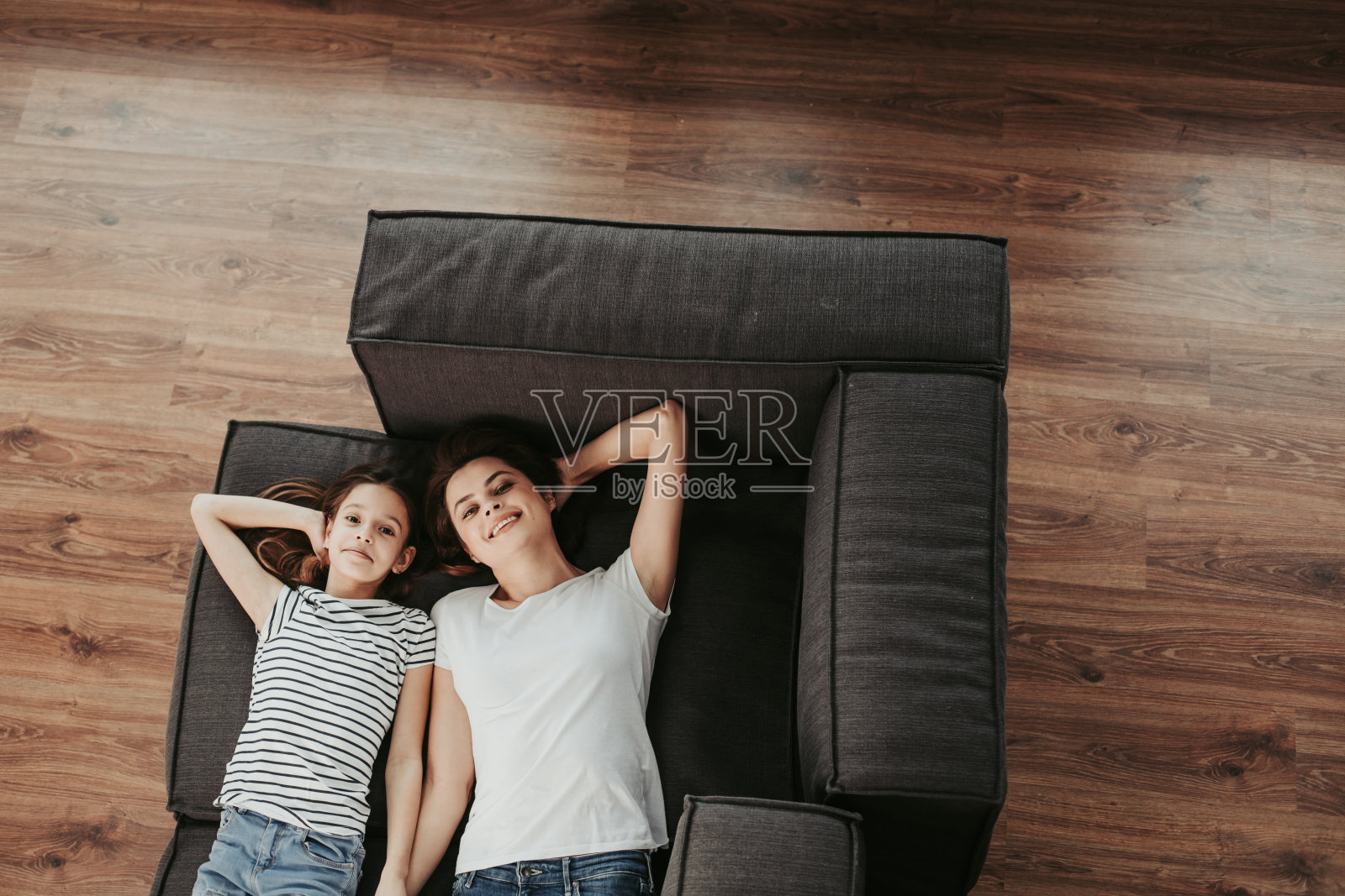 幸福的母亲和女儿躺在沙发上照片摄影图片