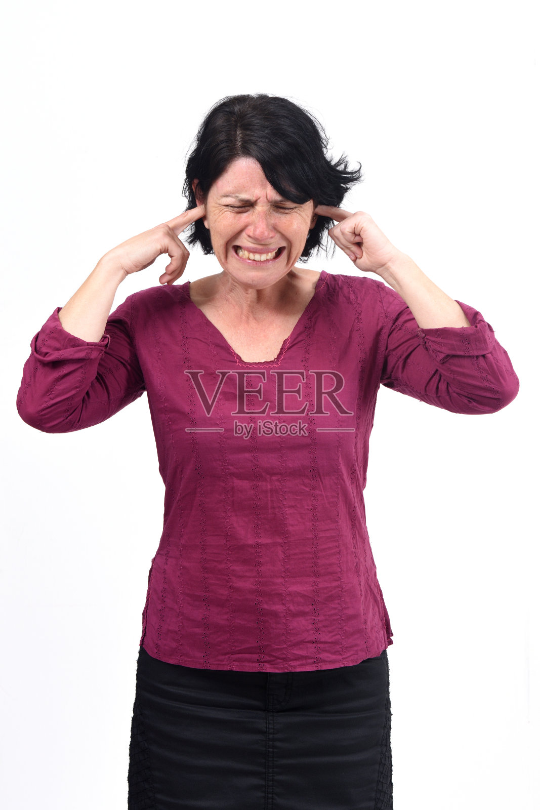 一个女人在白色背景下制造噪音伤害她的耳朵照片摄影图片