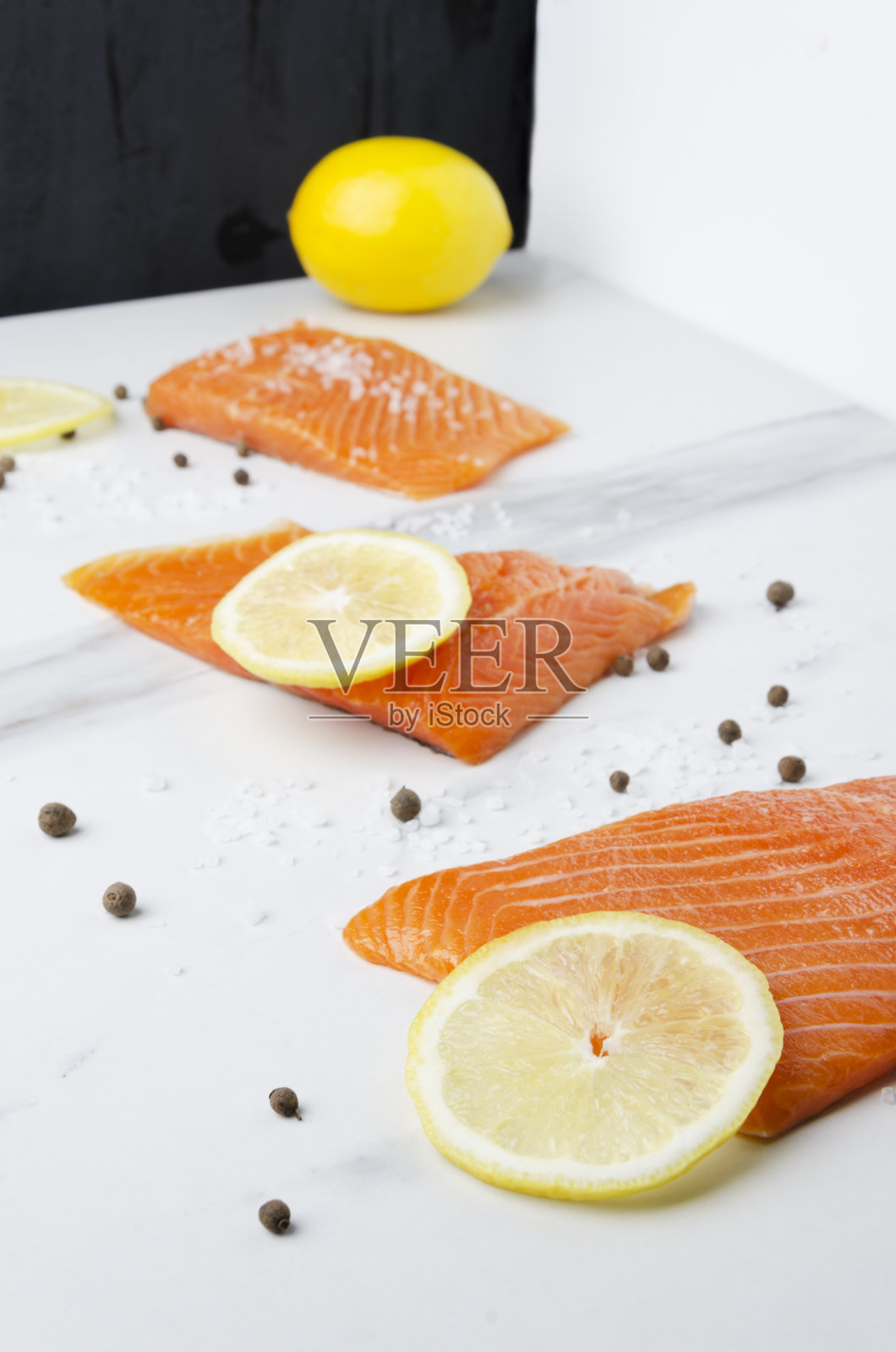 在厨房里用黄柠檬和胡椒烹制美味的生鲑鱼照片摄影图片