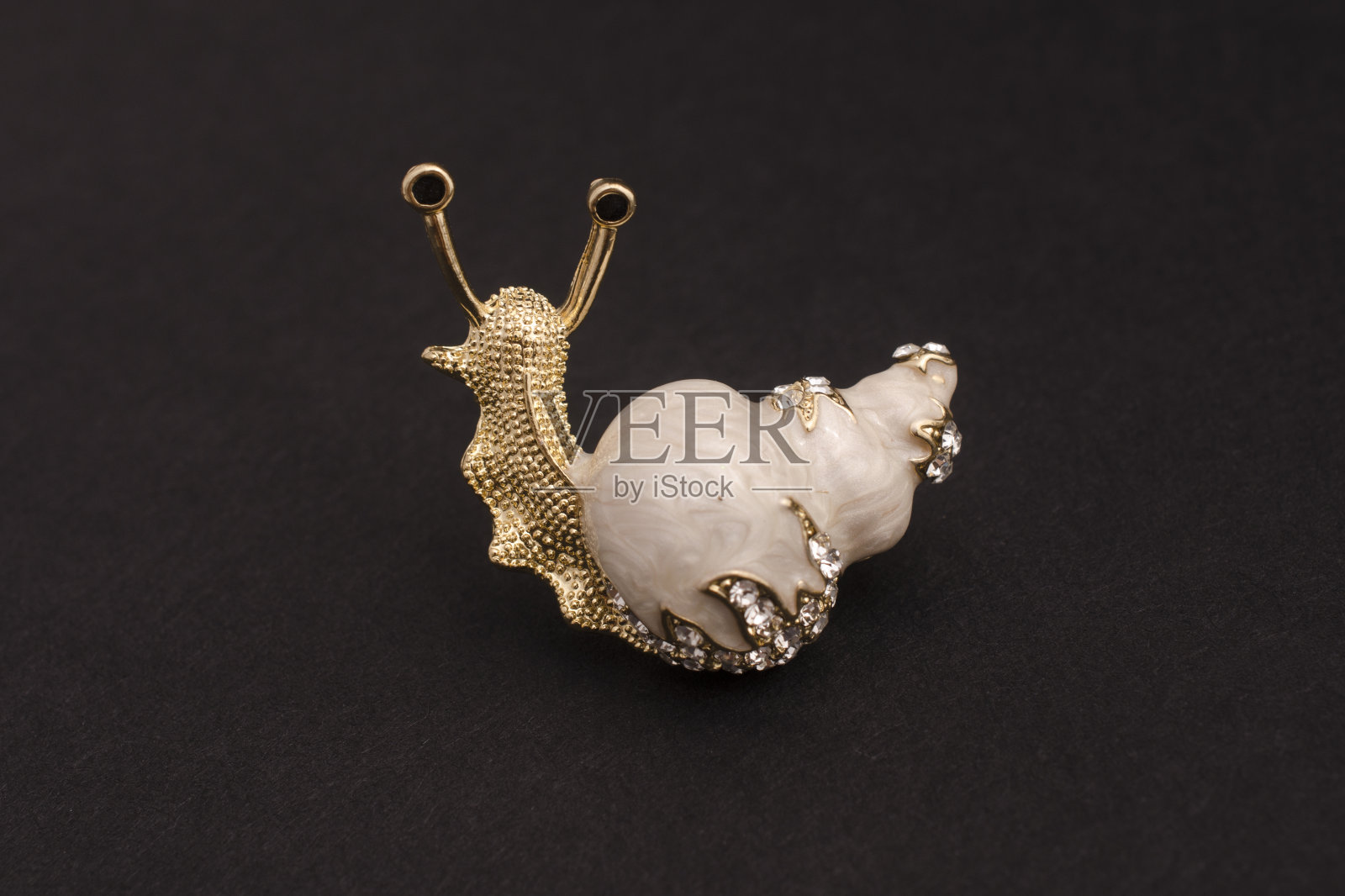 金搪瓷胸针蜗牛与钻石孤立在黑色照片摄影图片