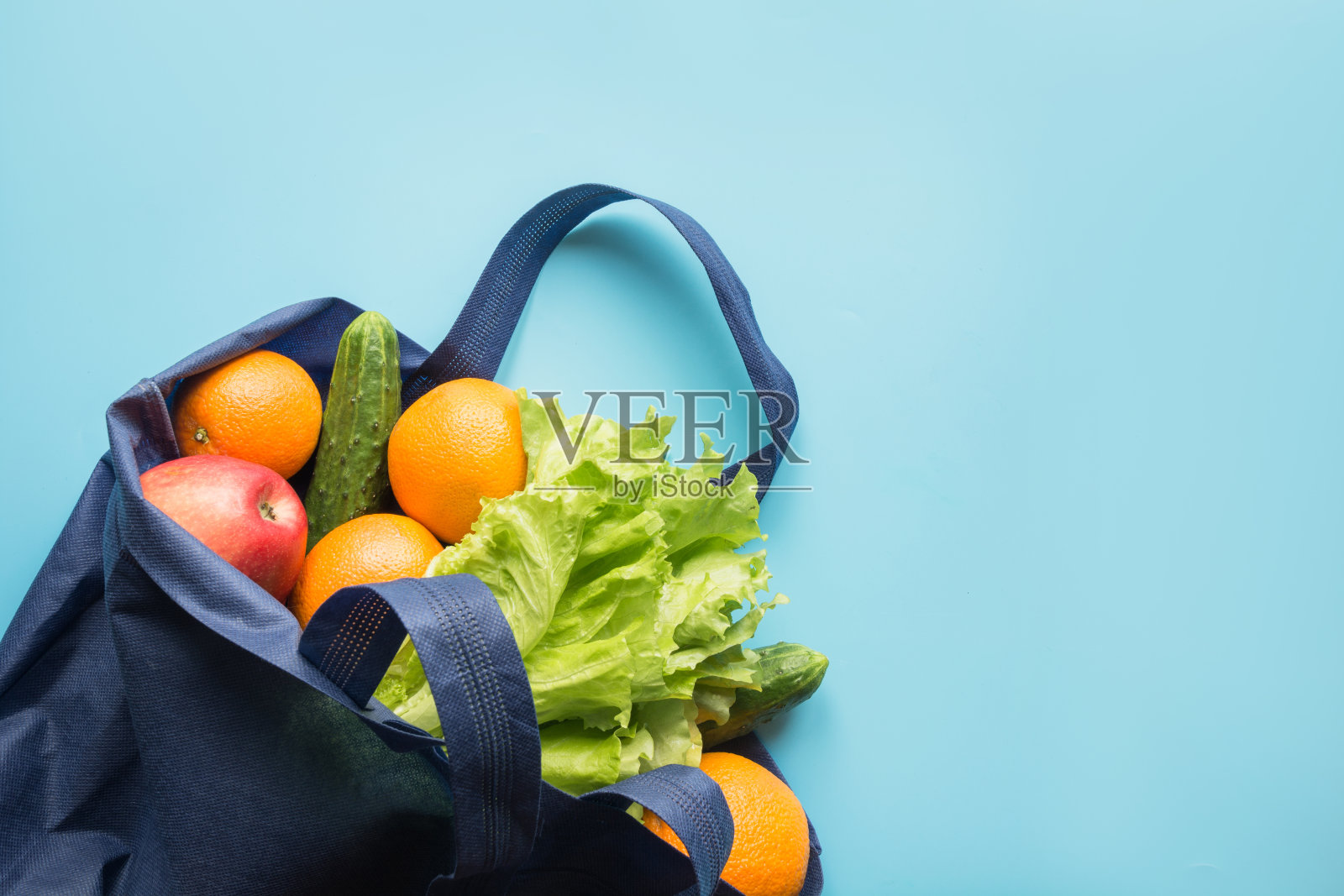 “零浪费”的概念。蓝色购物棉袋，新鲜的橘子和蔬菜。空间的文本。照片摄影图片