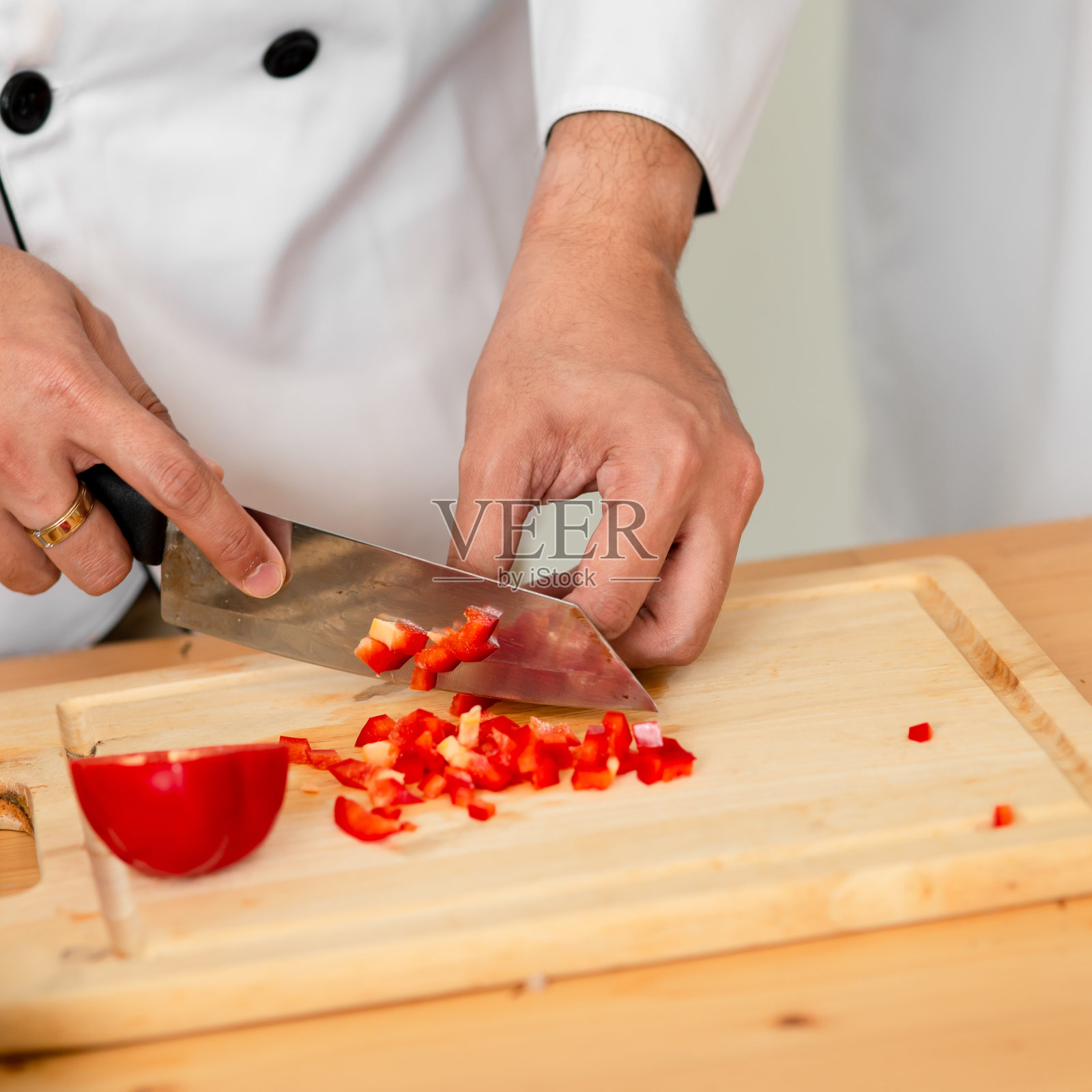 厨师在切菜板上切黄辣椒，工作理念。照片摄影图片