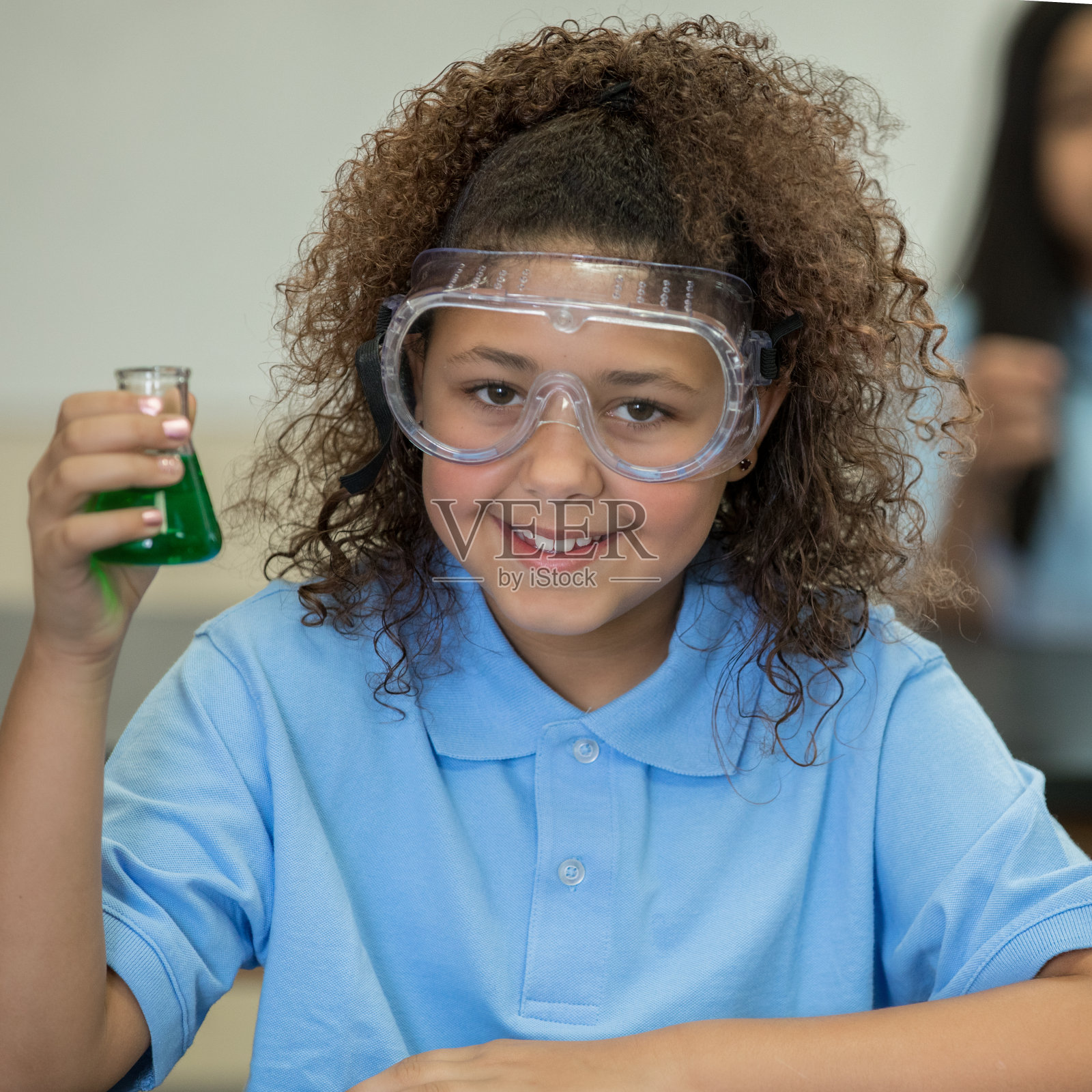 一个十多岁的小女孩在私立学校的化学课上做科学实验时微笑照片摄影图片