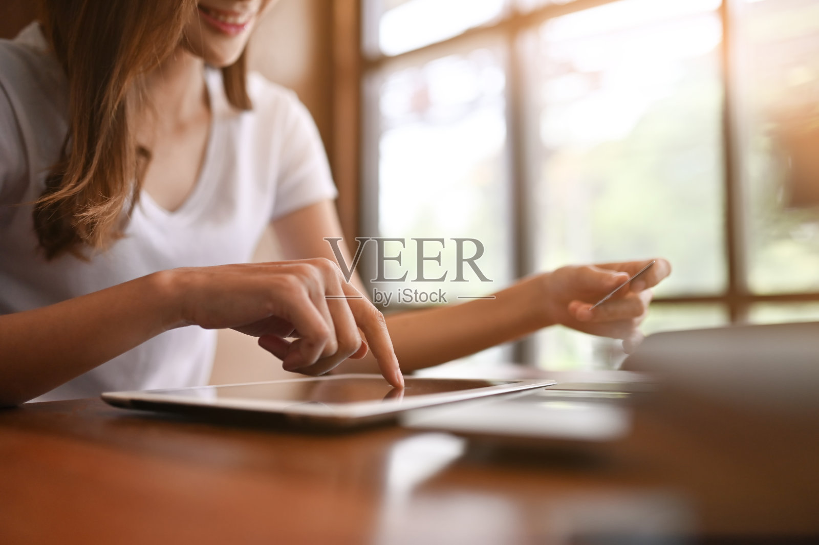 网上购物，女人用平板电脑和拿着信用卡在桌子上。照片摄影图片
