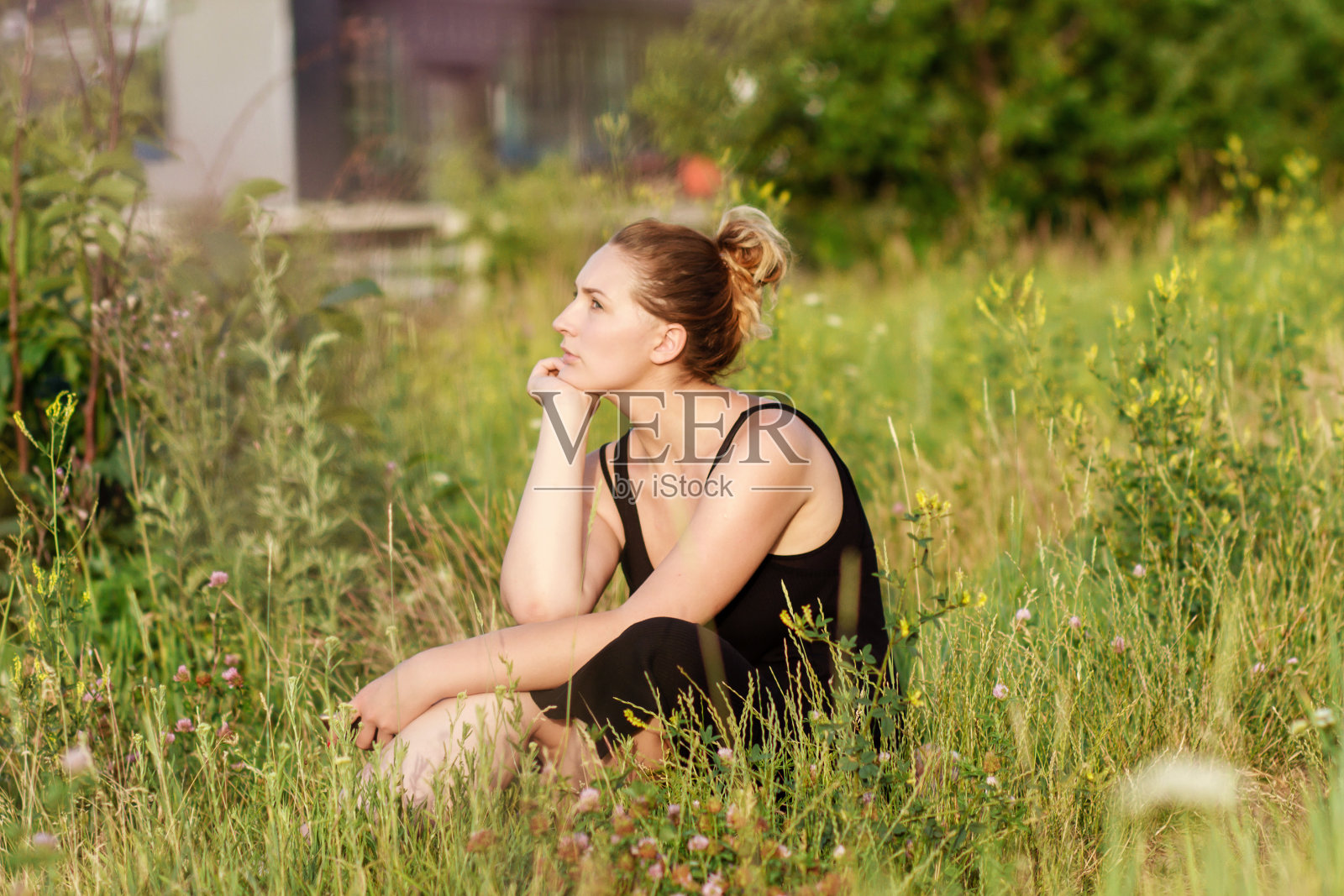 年轻女子坐在草地上照片摄影图片