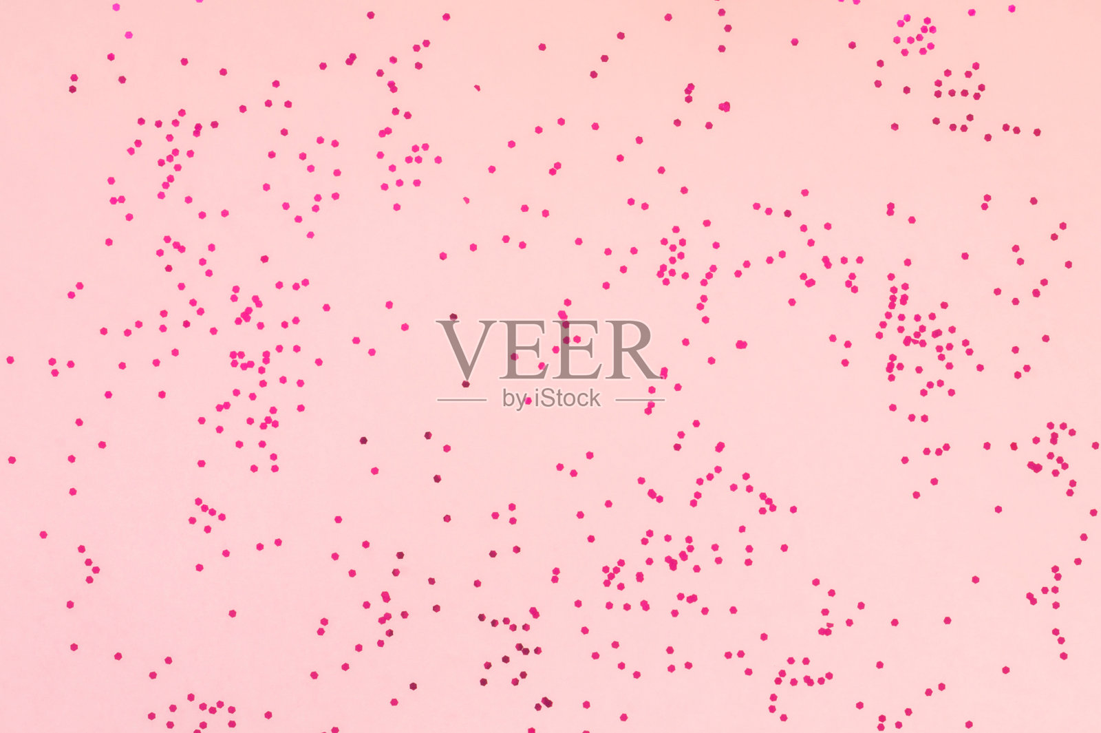 亮粉色的五彩纸屑点缀在柔和的粉红色背景上。节日色彩柔和的背景。庆祝活动的概念。俯视图，平放。水平插画图片素材