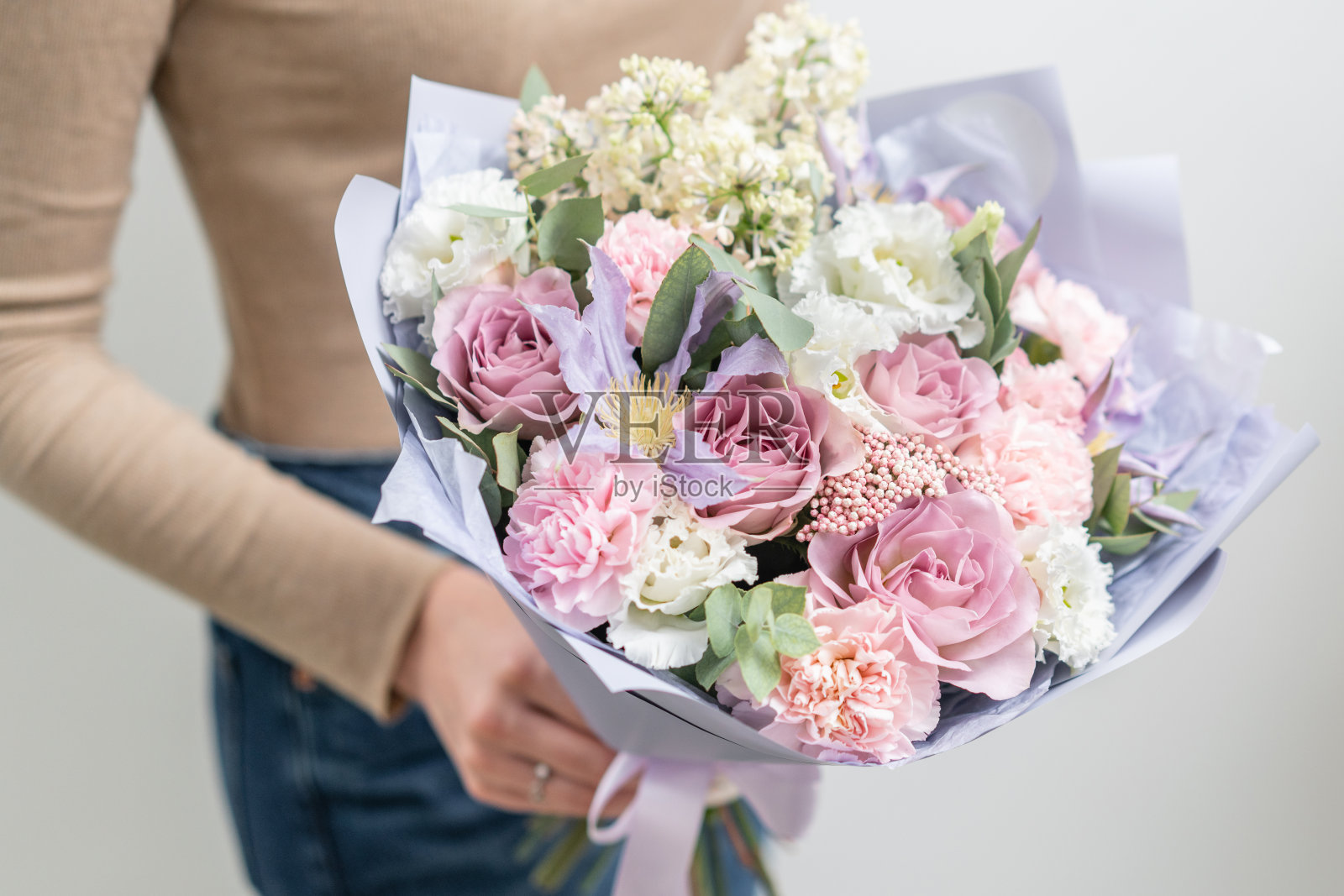 女人手里拿着一束美丽的混合鲜花。花店花匠的工作。精致柔和的颜色。新鲜切花。粉红色和淡紫色照片摄影图片