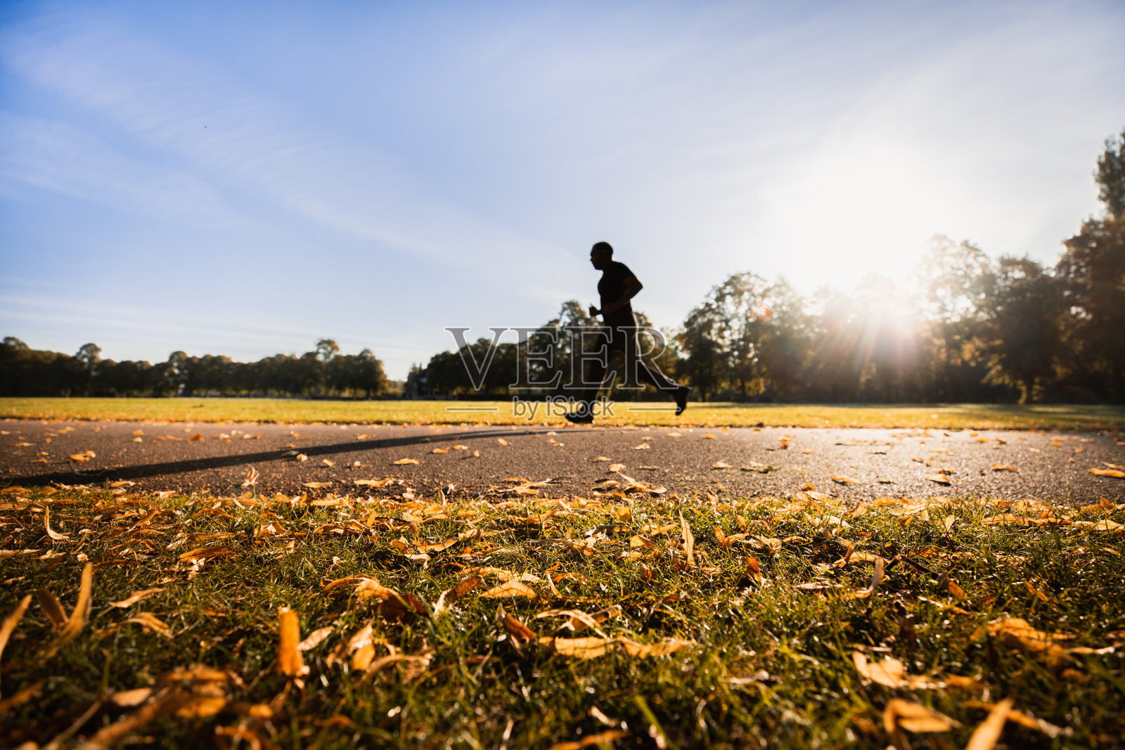 在英国城市公园，阳光明媚的一天晨跑照片摄影图片