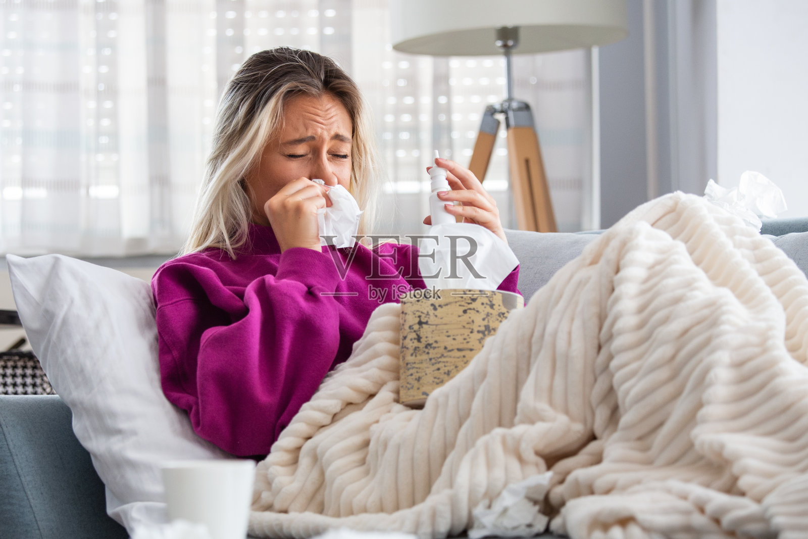 绝望的女人得了流感鼻炎、感冒、疾病、过敏概念。漂亮的女病人流鼻涕，用手帕擦鼻子。打喷嚏的女性。褐发女人用纸巾打喷嚏照片摄影图片