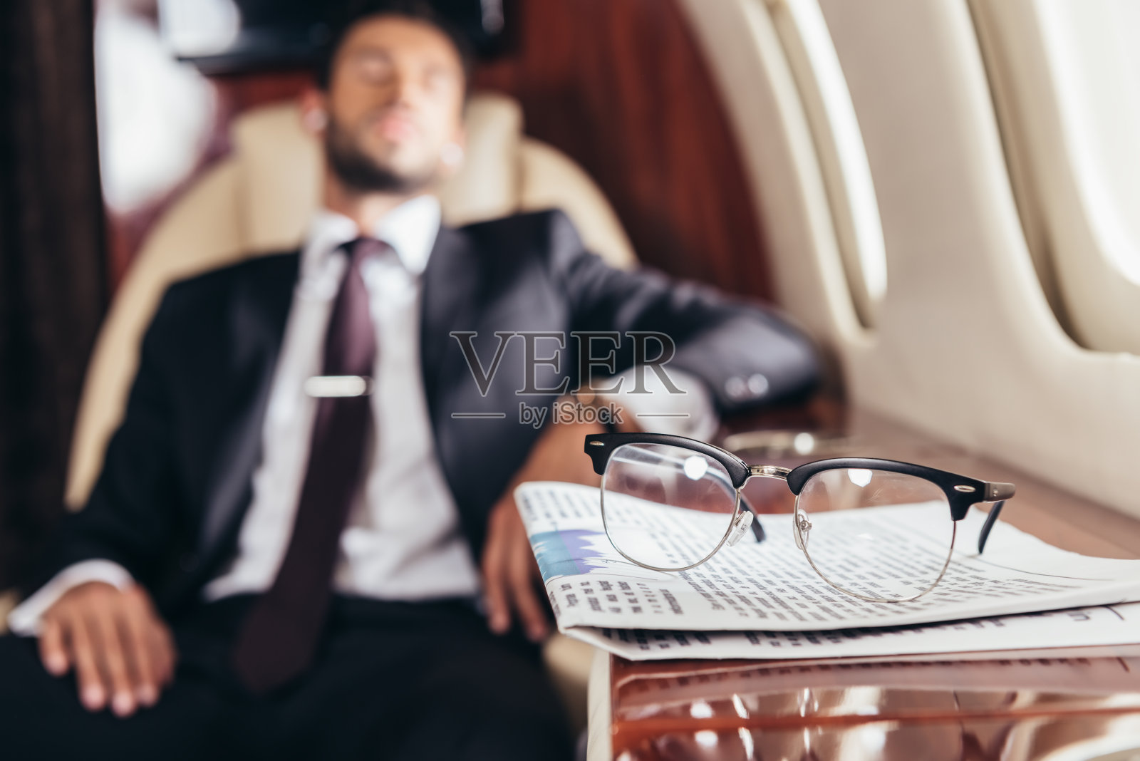 私人飞机桌上的眼镜和报纸选择性聚焦照片摄影图片