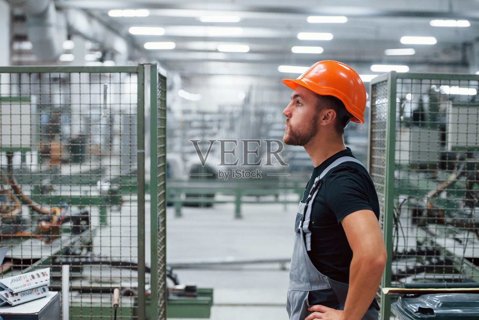 工厂内的工业工人。戴着橙色安全帽的年轻技术员照片摄影图片