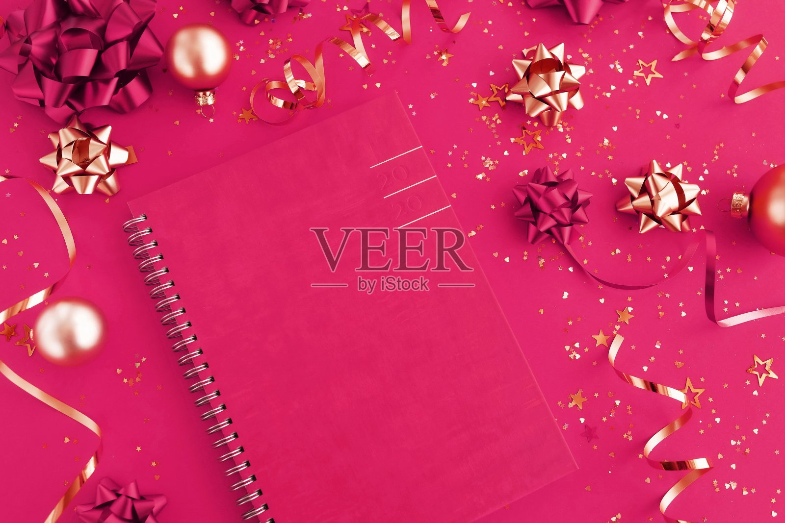 圣诞节或新年的框架装饰在金色和笔记本粉红色的背景与空白的文本复制空间。明信片或邀请的圣诞节，假日和庆祝概念。俯视图照片摄影图片