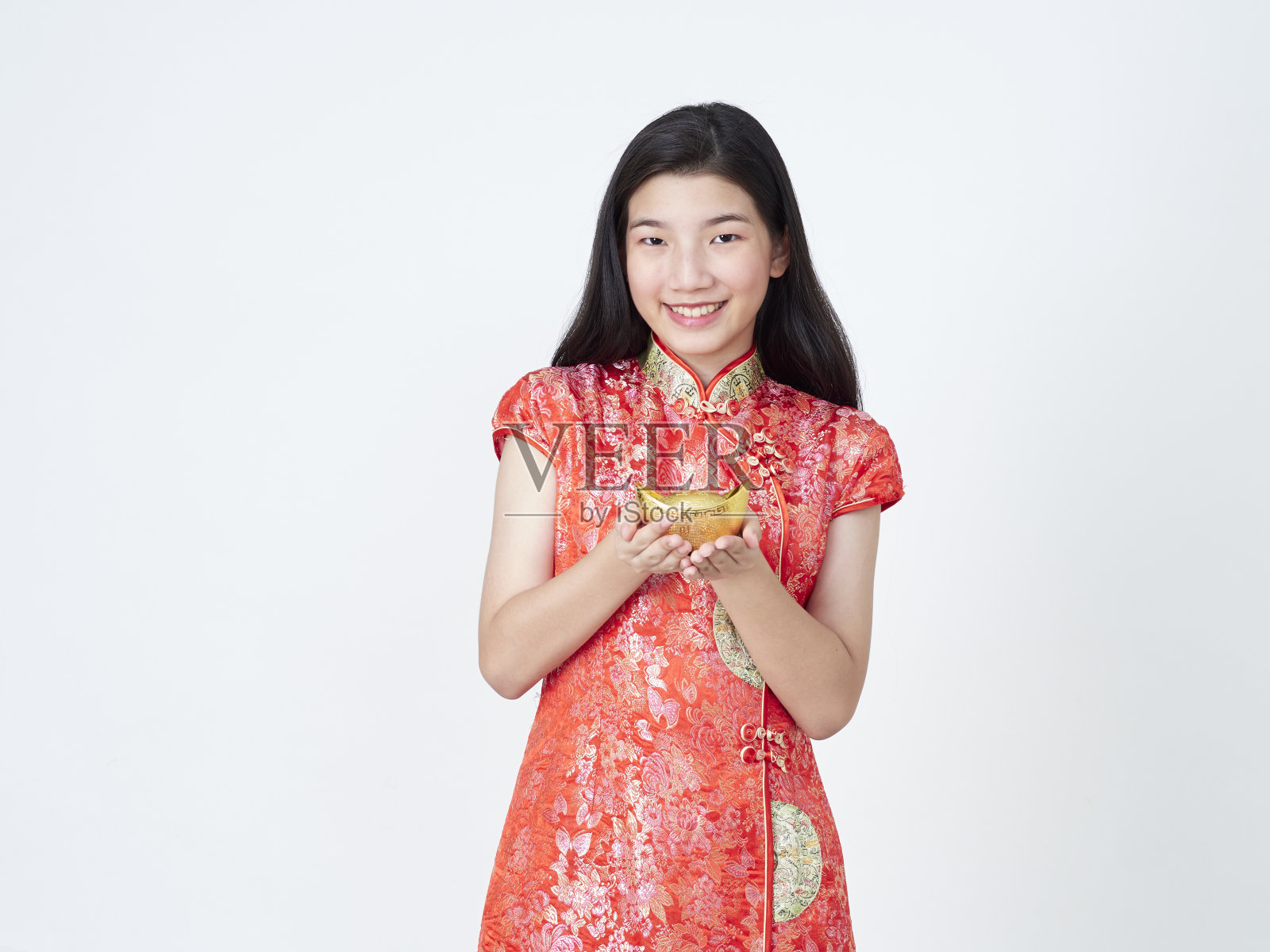 2020年中国新年。身着中国传统旗袍的年轻女子手持白色背景上的中国黄金照片摄影图片