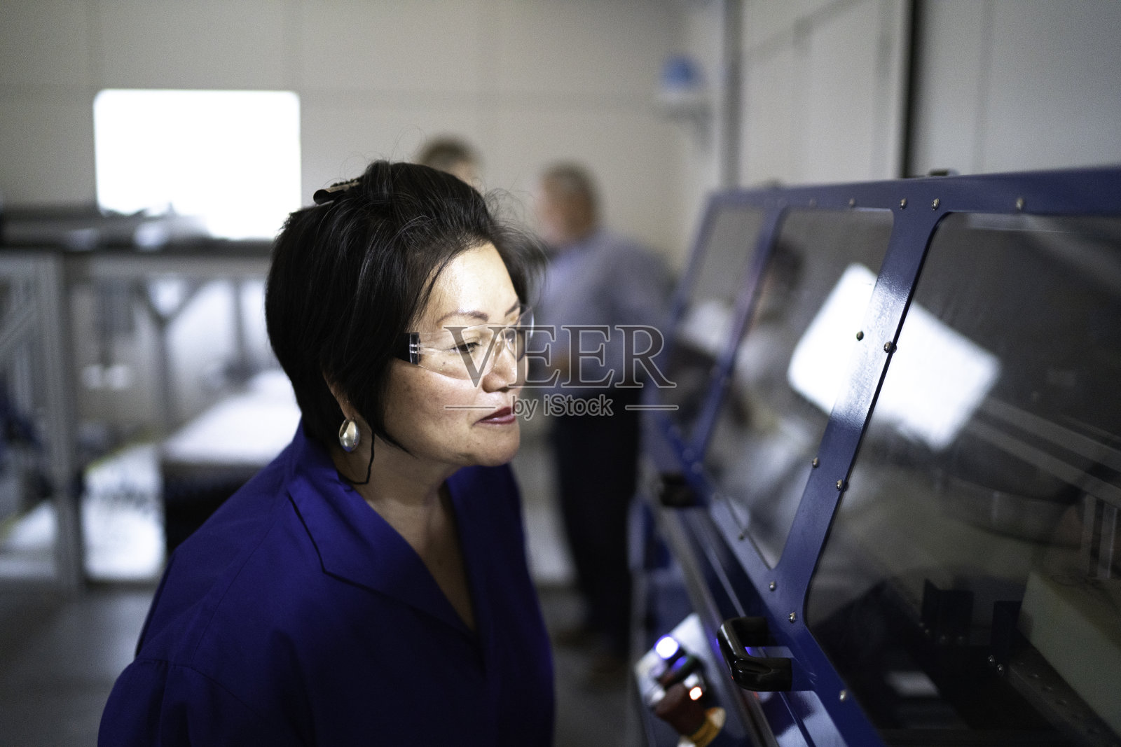 在工业中使用机械的成熟员工照片摄影图片