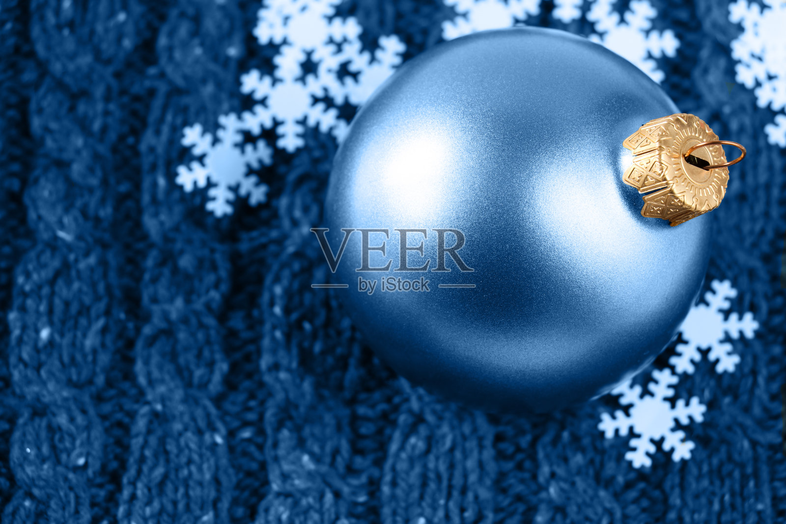 圣诞蓝球在羊毛编织的背景上装饰雪花。照片摄影图片