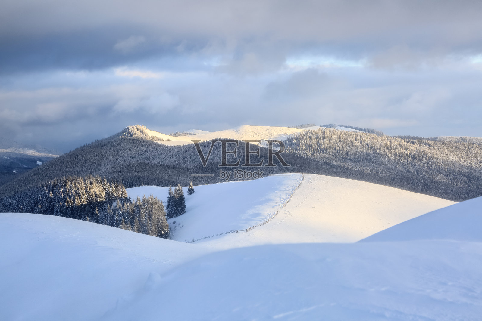 冬天的风景。木栅栏。高山，森林和天空与云彩的美丽景观。草坪上覆盖着白雪。壁纸的背景。地点:欧洲，乌克兰，喀尔巴阡。照片摄影图片