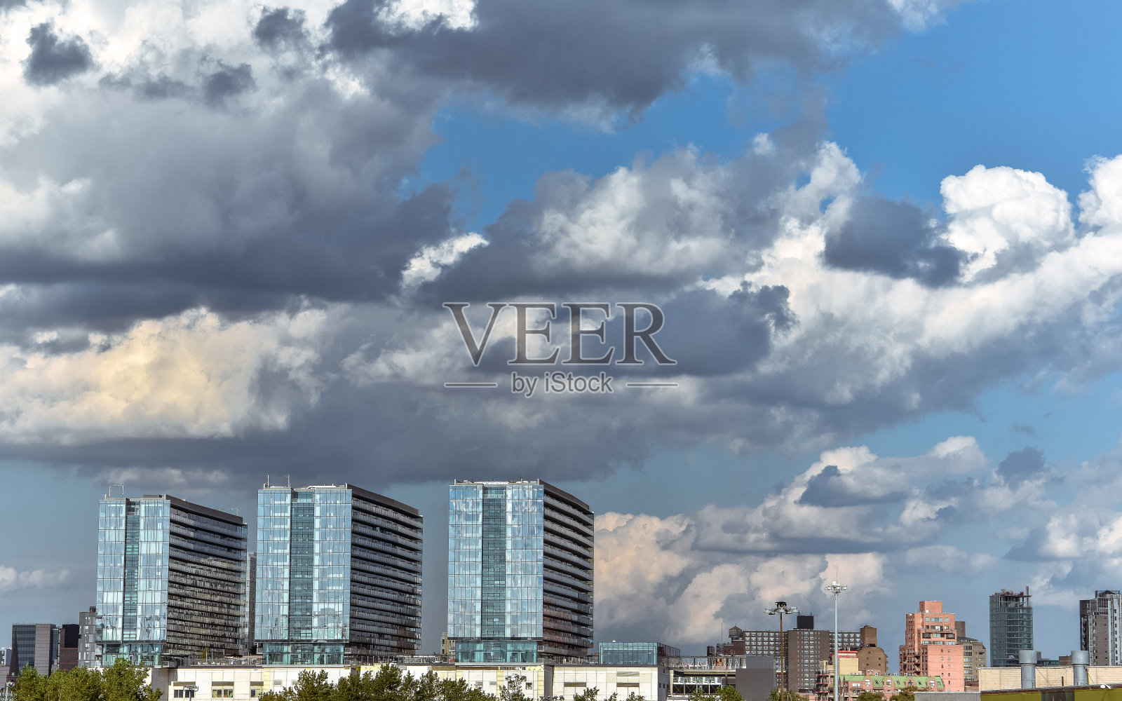一般的城市景观与多云的蓝天。三排主楼在天际线上。天气和城市概念。纽约市。美国。照片摄影图片