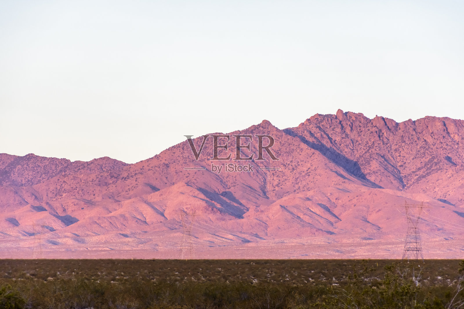 美国加利福尼亚州莫哈韦沙漠，日落时分的多山沙漠景观中的电力塔照片摄影图片