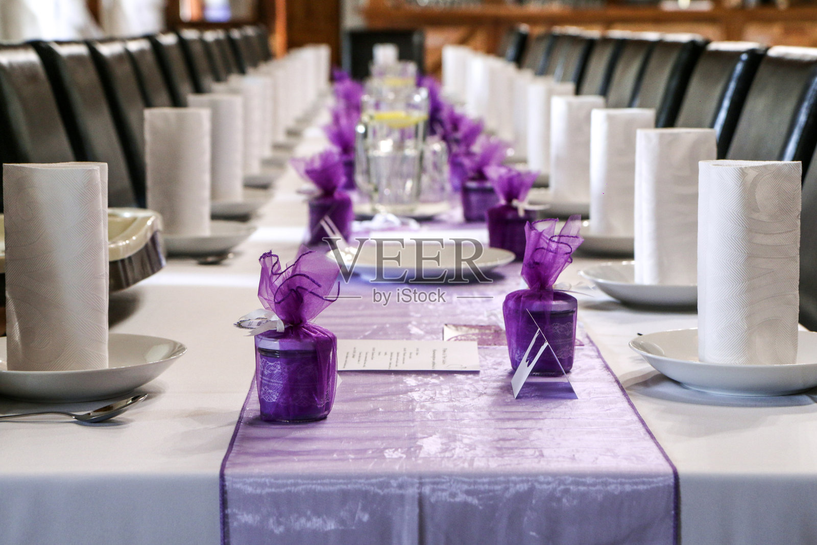 为婚礼准备的午餐桌子的详细图片。所有的配件都是紫色的。照片摄影图片