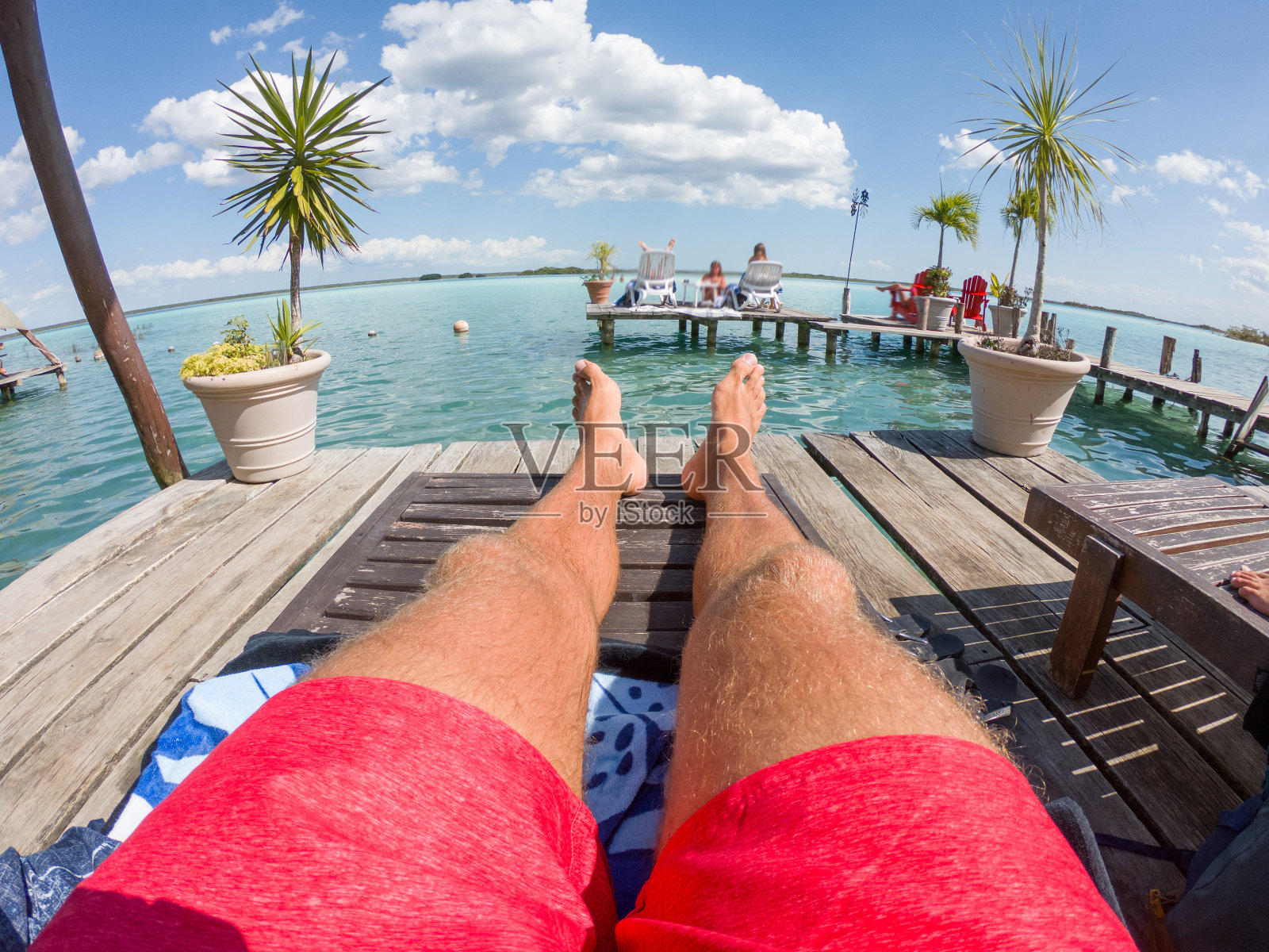 个人视角的男人放松在墨西哥泻湖上的太阳椅上照片摄影图片