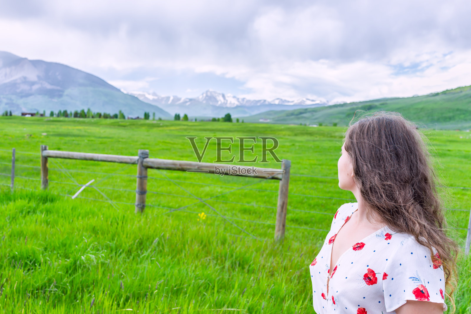 crest Butte，科罗拉多州的观点在夏天的落基山脉与年轻的女人女孩看牧场农场和篱笆照片摄影图片