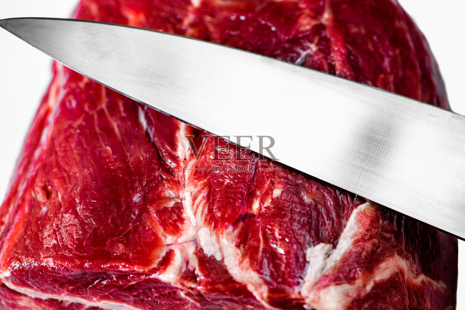 用菜刀切生牛肉。照片摄影图片