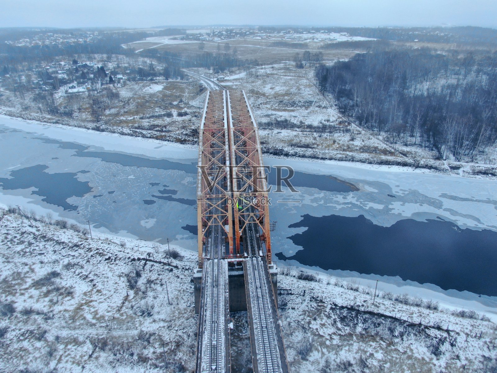 鸟瞰图，无人机拍摄铁路桥上冰冷的河流。美丽的冬季自然全景景观照片摄影图片