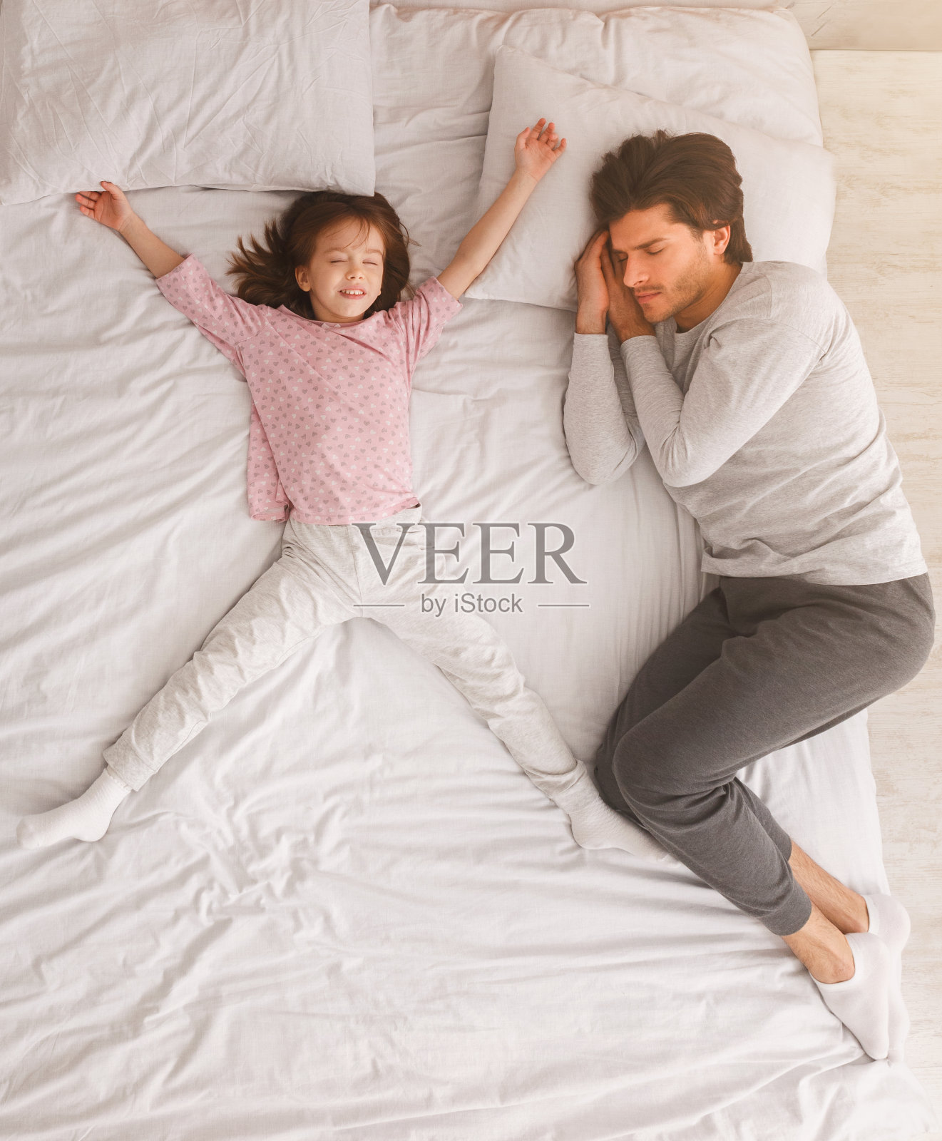 爸爸和小女孩一起睡在床上照片摄影图片