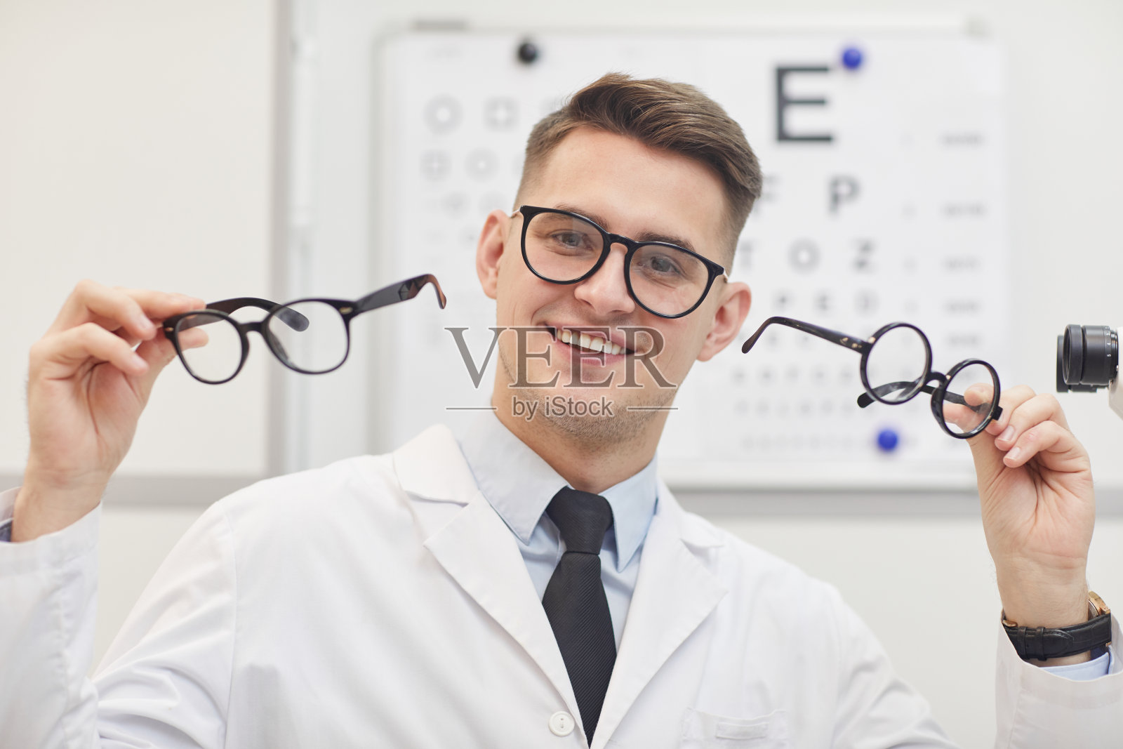 微笑的眼科医生拿着眼镜照片摄影图片