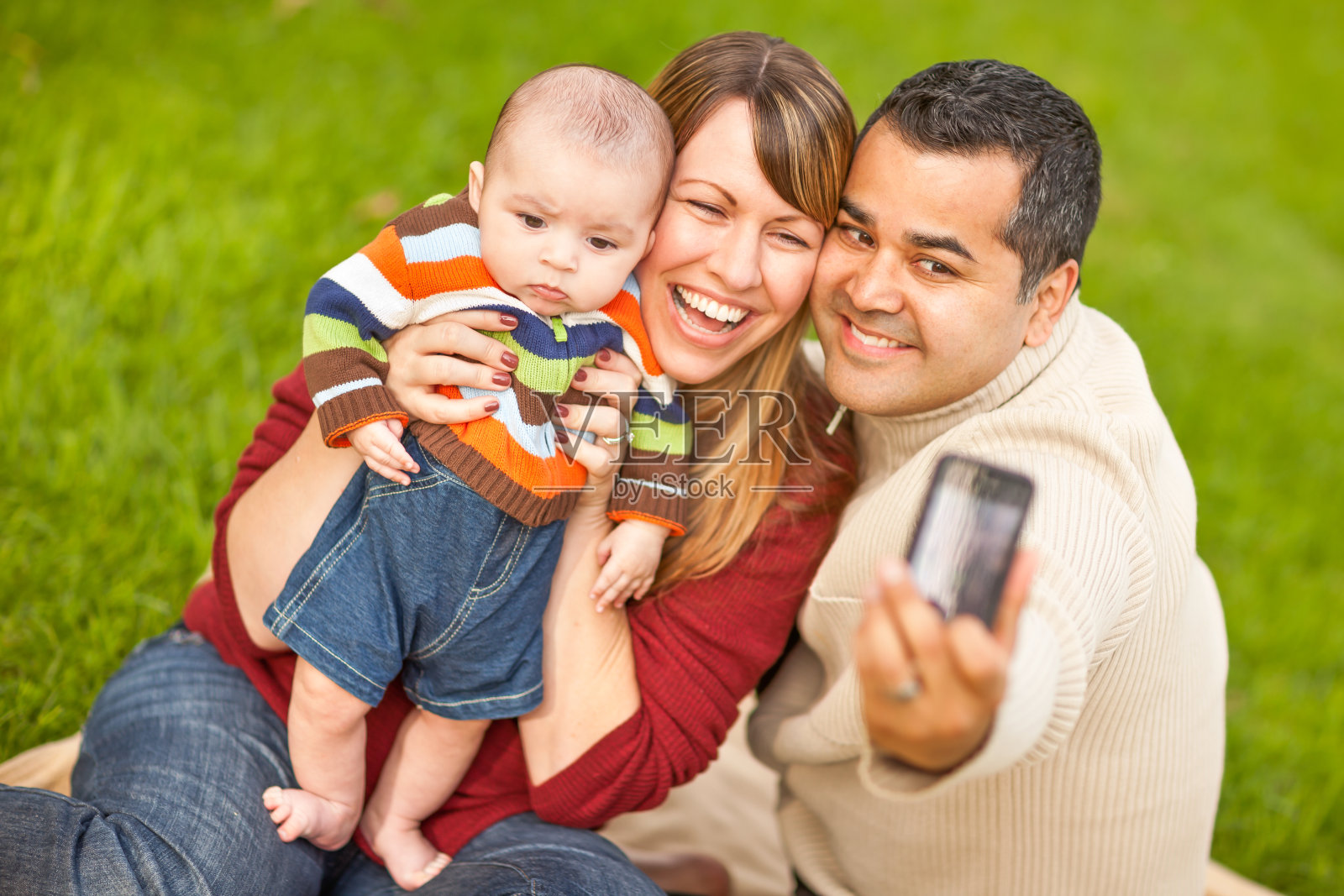 快乐的混血父母和男婴在公园里自拍照片摄影图片