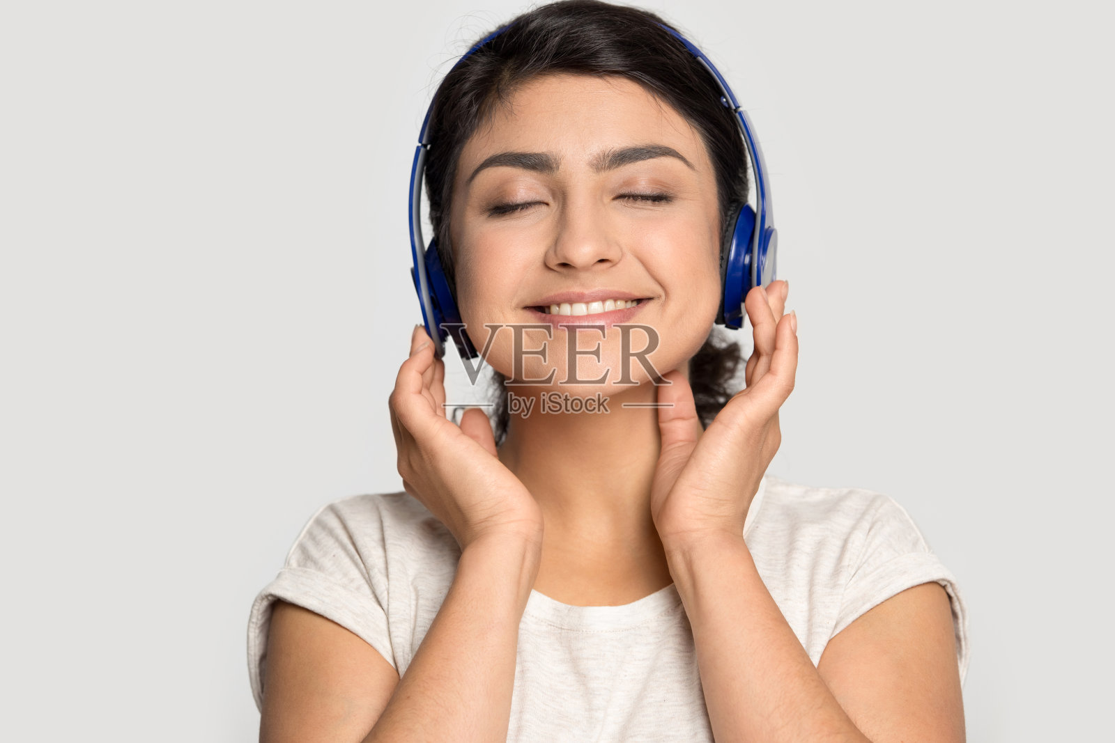 快乐微笑的印度裔女孩享受着最喜欢的音乐。照片摄影图片
