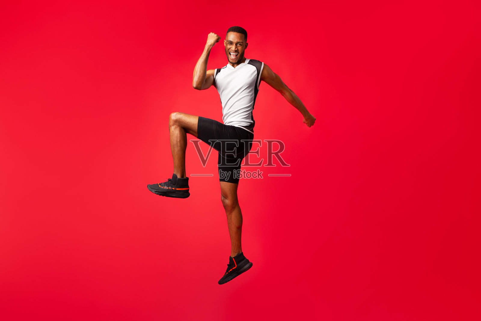 长着非洲头的家伙在工作室庆祝成功跳跃照片摄影图片