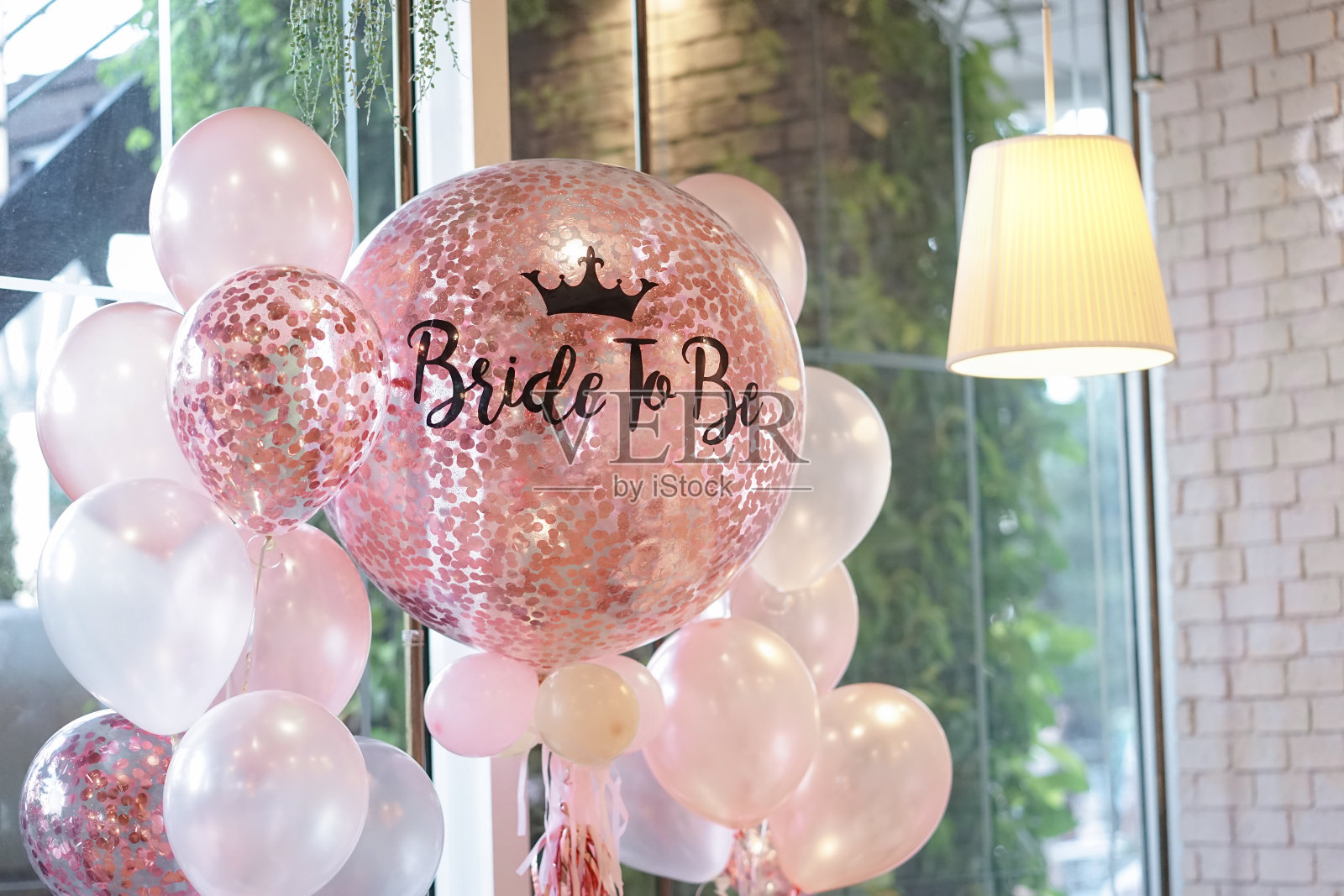 粉红色的气球。粉色和白色的氦气球装饰着女性聚会，上面写着“即将成为新娘”的字样。照片摄影图片