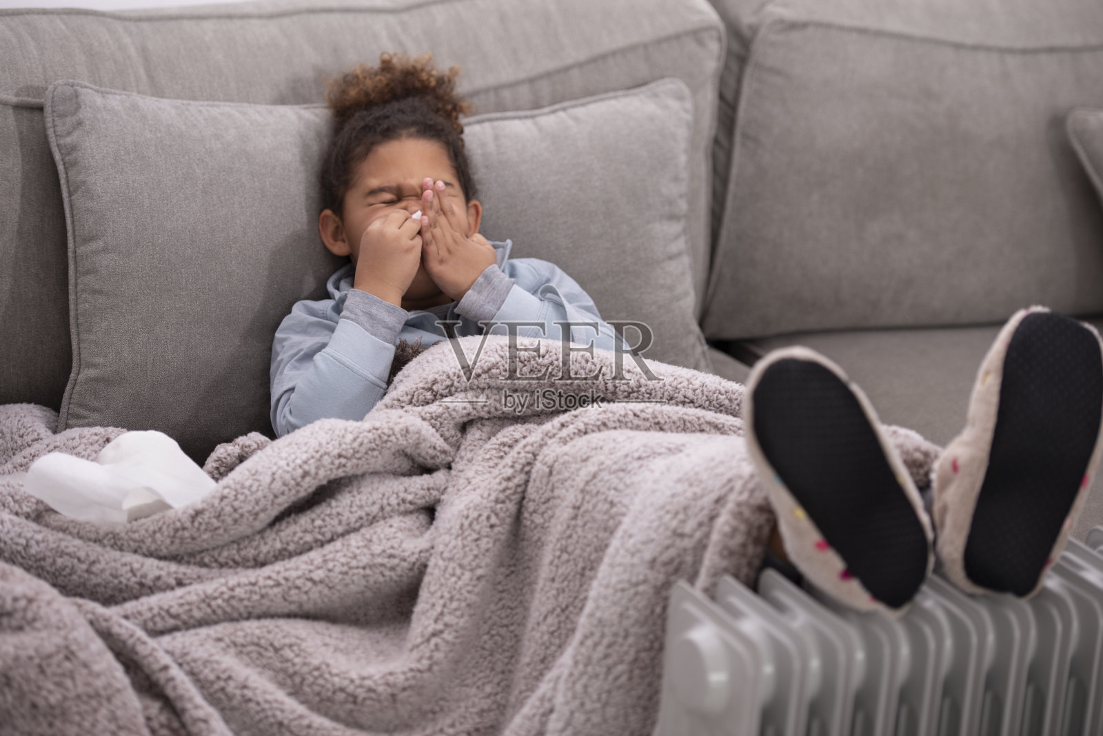 一个生病的女孩感冒了，在纸巾里打喷嚏。照片摄影图片