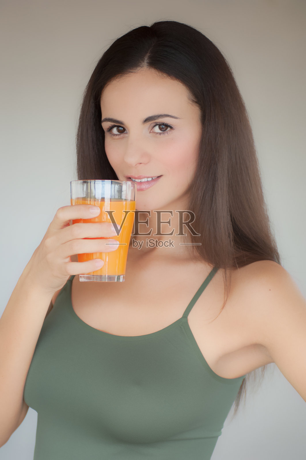 一头长发的美女端着一杯橙汁照片摄影图片