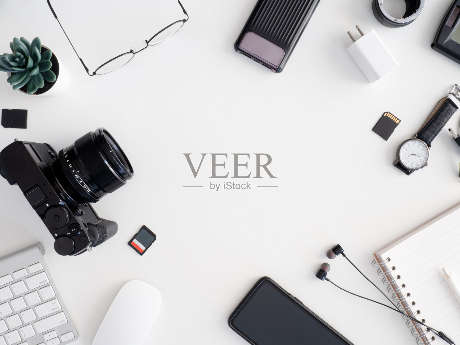 俯视图的摄影师工作站，工作空间的概念与数码相机，存储卡，键盘和智能手机在白色的桌子背景照片摄影图片