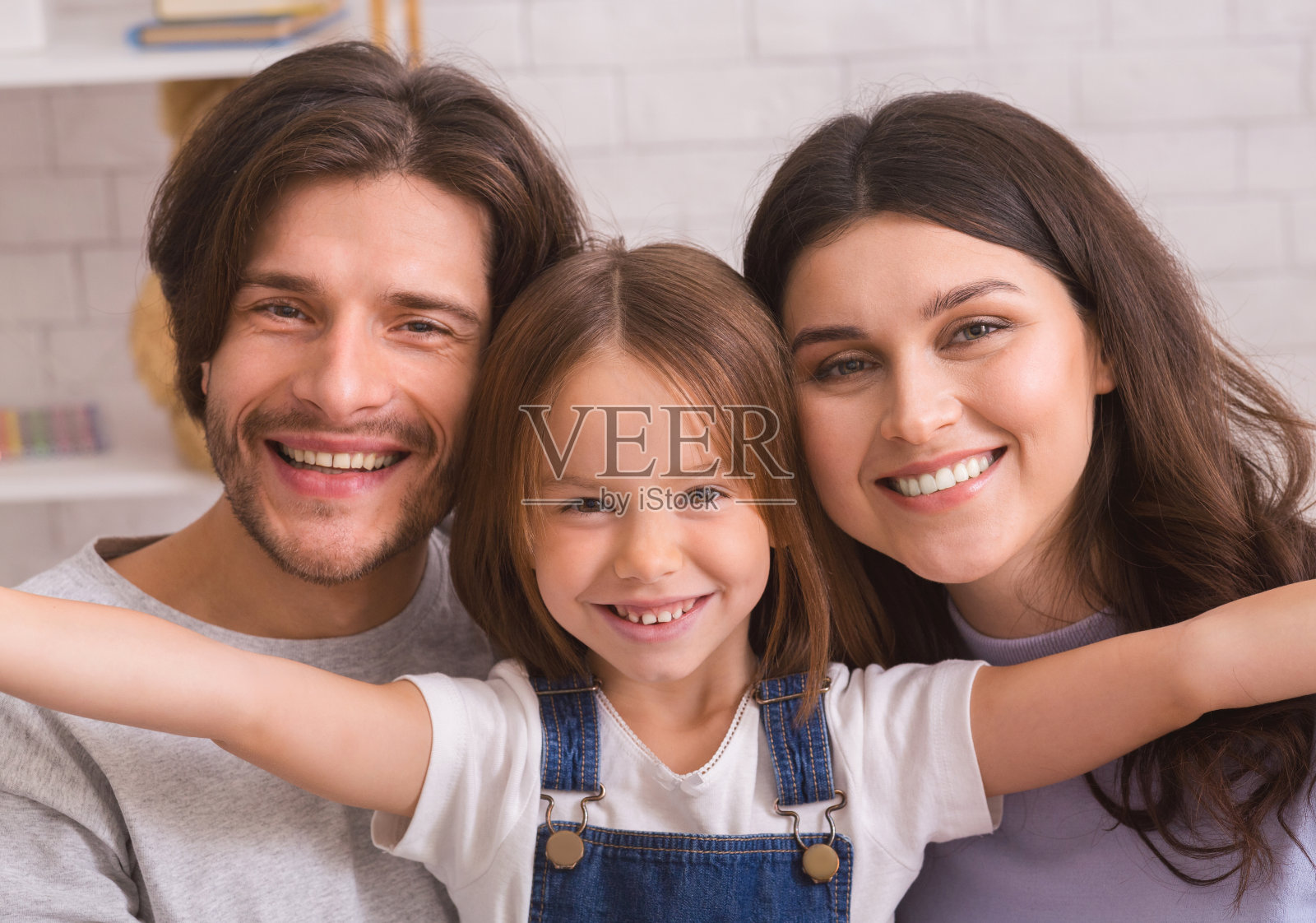 可爱的小女孩和她的父母在家里自拍照片摄影图片