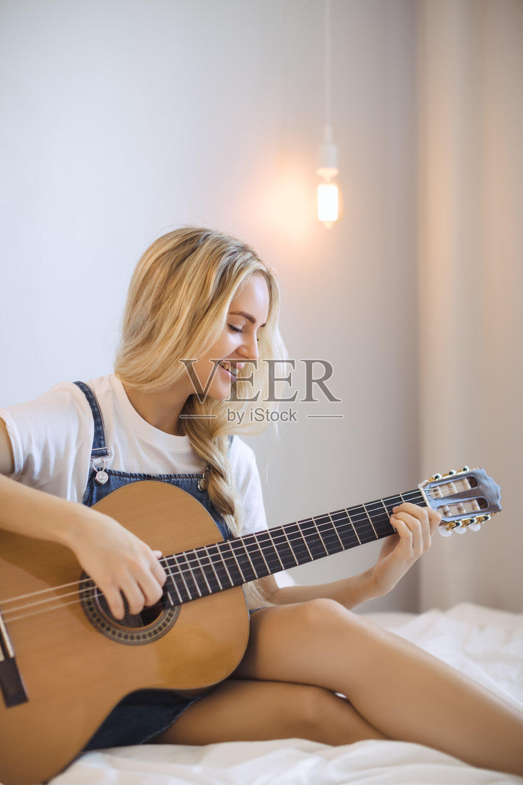 一个女孩在家里学习弹吉他照片摄影图片