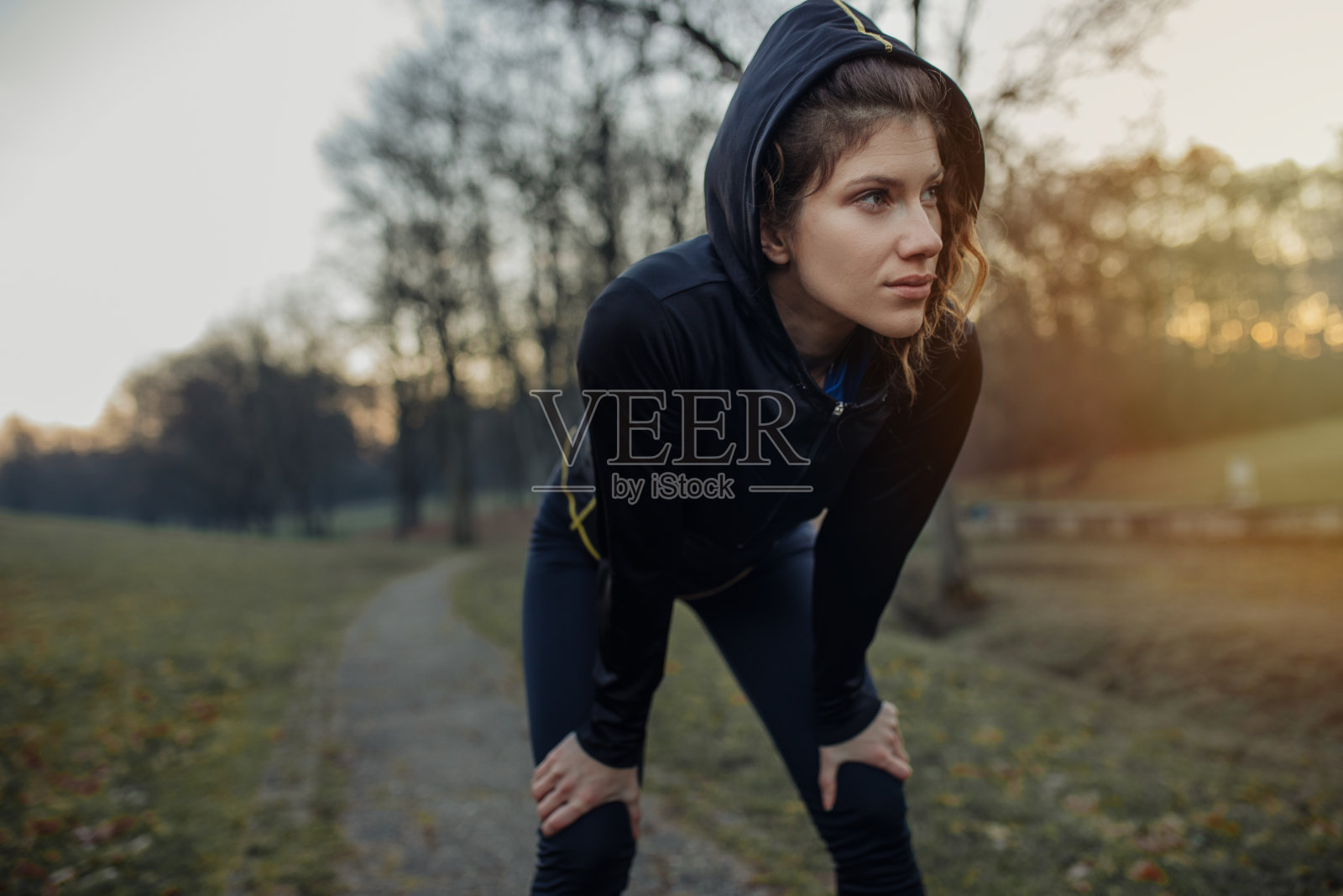 年轻的运动员在公园里锻炼身体。年轻女子在公园里跑步照片摄影图片
