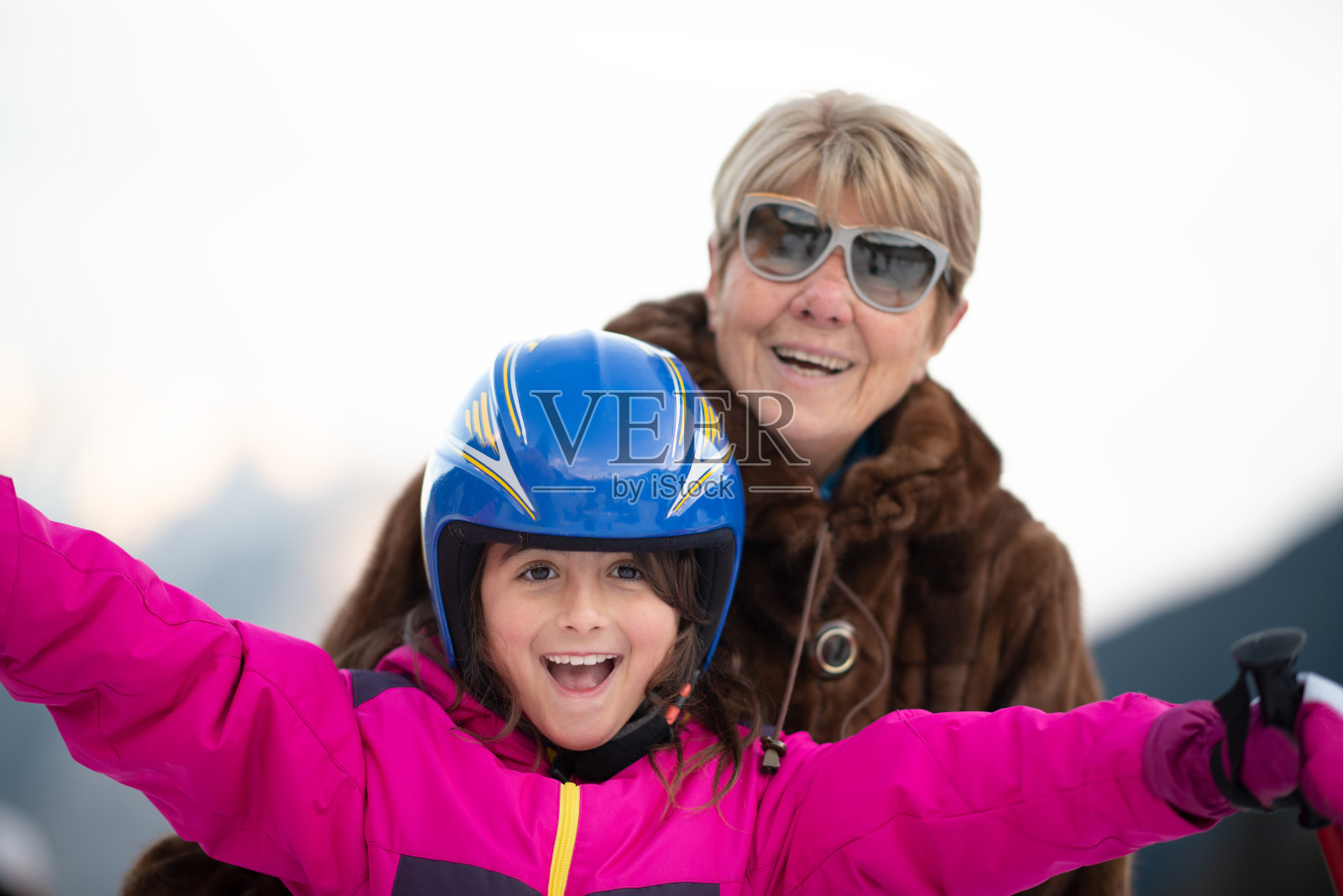 爷爷奶奶的爱。微笑的奶奶和孙女在滑雪度假照片摄影图片