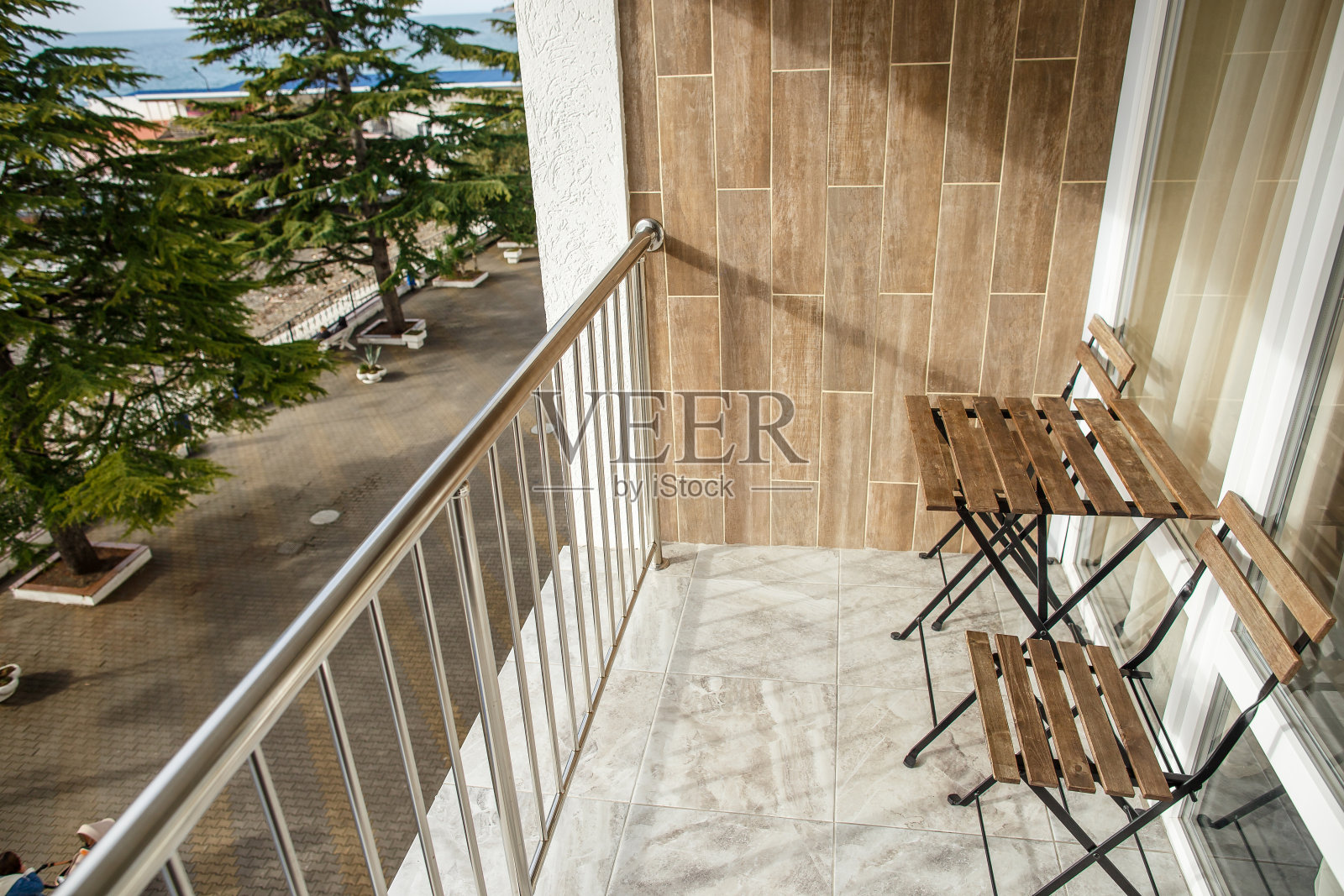 开放的海边阳台上的木椅和桌子。照片摄影图片