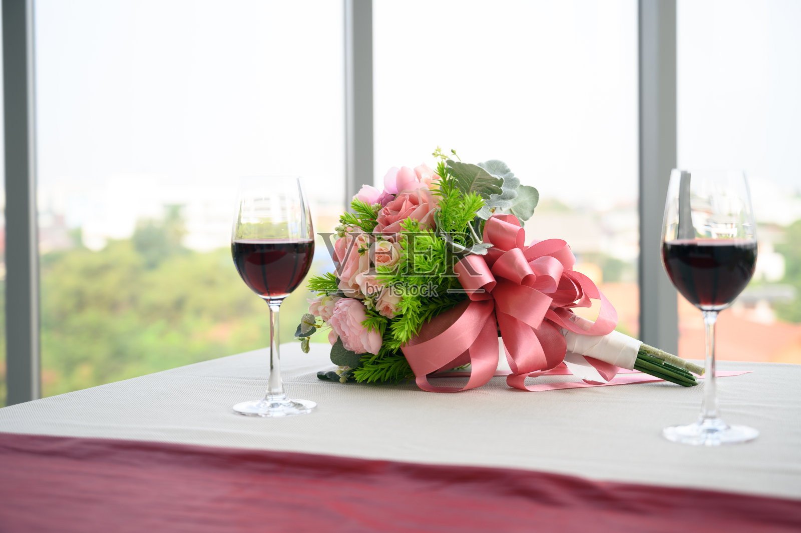 餐厅里浪漫的双人桌，红酒和美丽的玫瑰。照片摄影图片