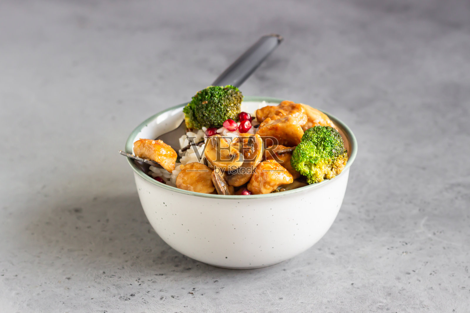 咖喱鸡饭，蘑菇，花椰菜，石榴籽。健康食品。亚洲美食。照片摄影图片