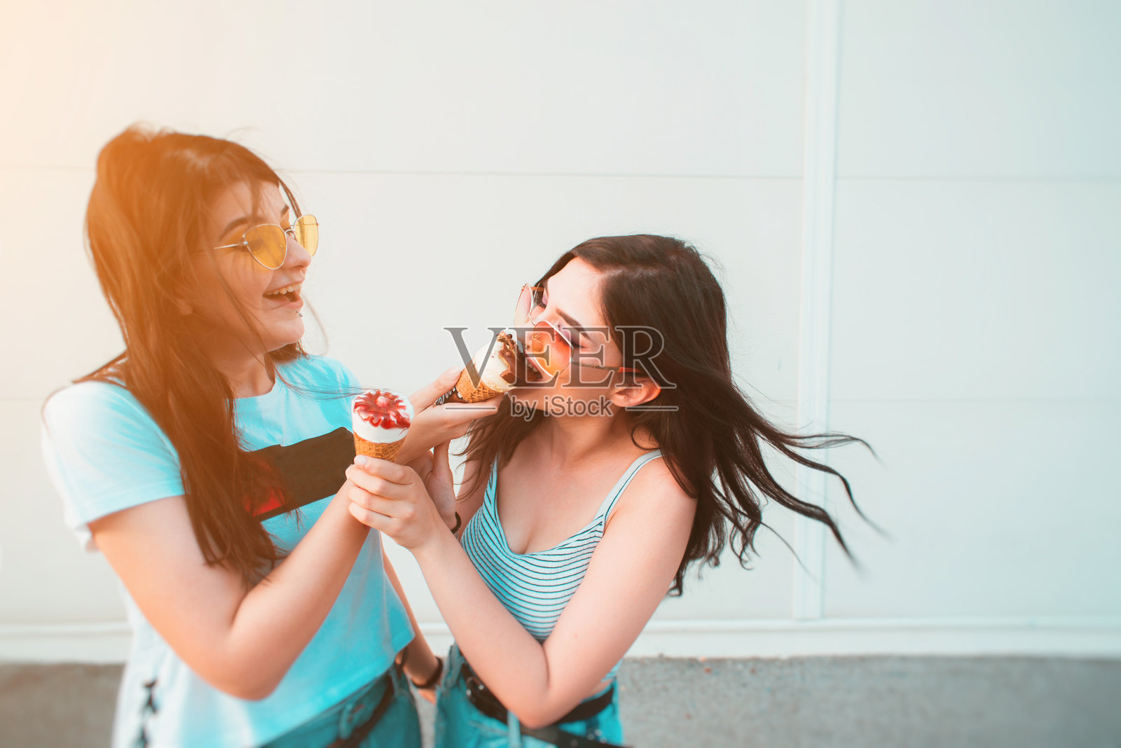 两个年轻的女性朋友分享冰淇淋照片摄影图片