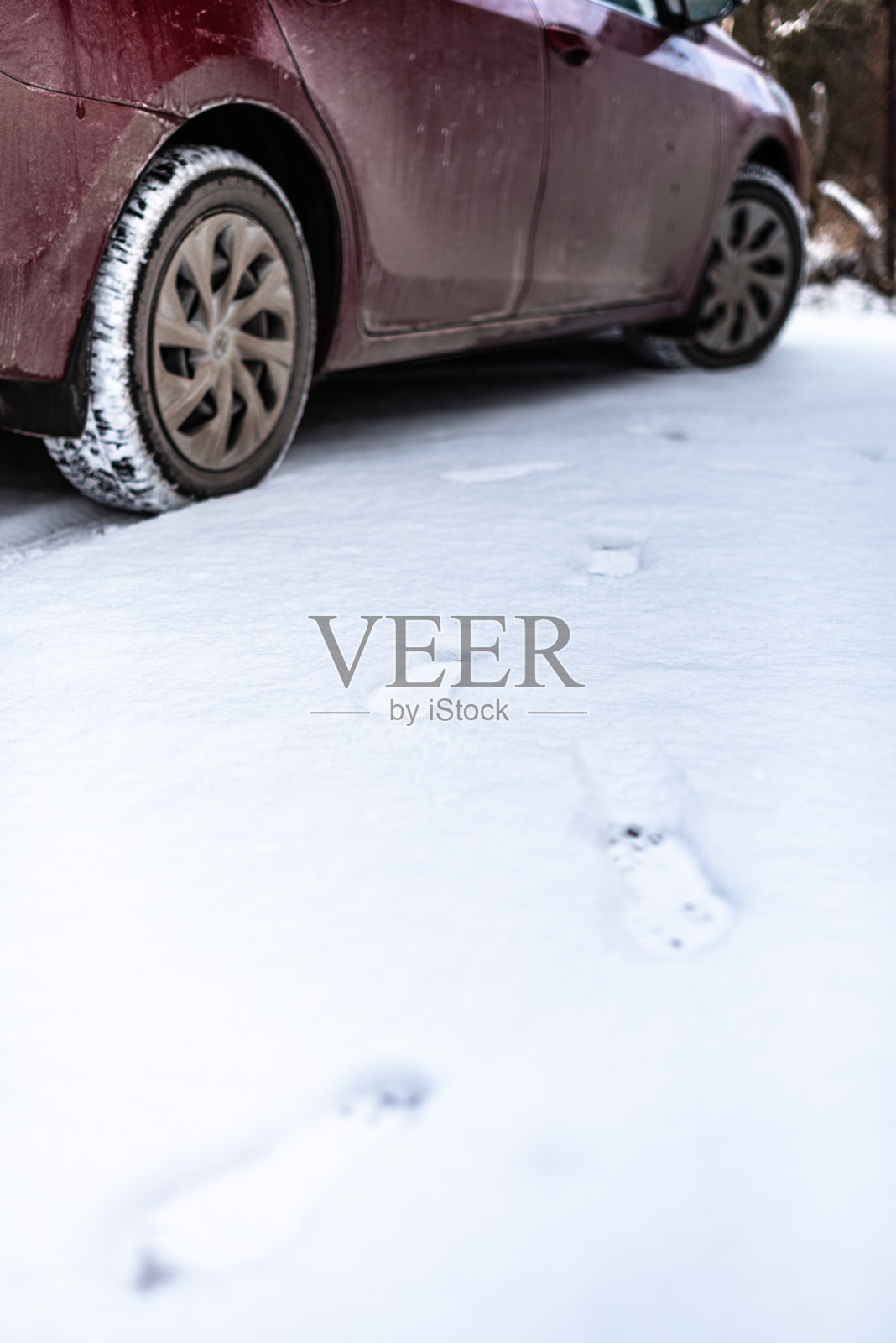 一只脚从雪地上的汽车里走出来，踏着轮胎，徒步行走照片摄影图片