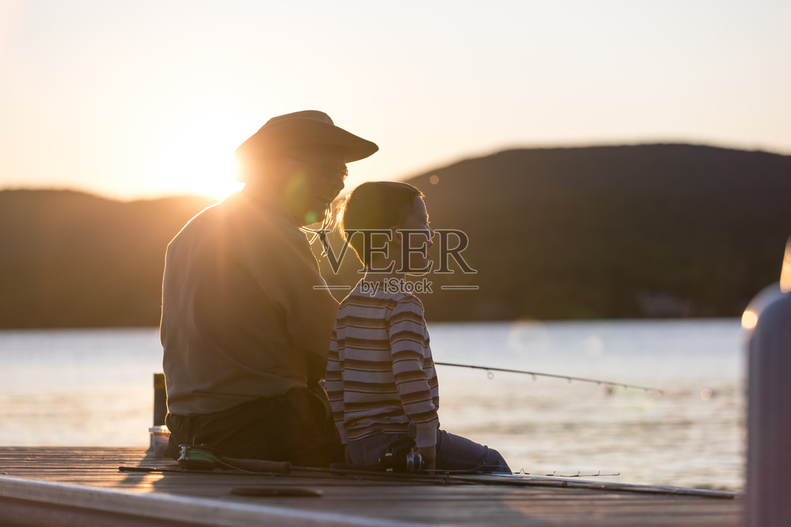 爷爷和孙子在夏天的日落钓鱼照片摄影图片